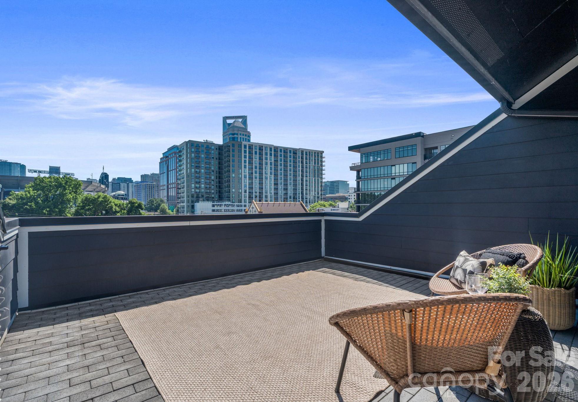 Experience stunning city views and luxury living at Altura Southend, located in Charlotte’s vibrant Southend neighborhood. This townhome showcases elevated design throughout, featuring custom high-end finishes, sleek modern details, and open-concept living spaces ideal for entertaining. The beautifully appointed kitchen features a large island, stainless steel appliances, and seamlessly flows into the main living areas. Upstairs, the breathtaking rooftop terrace is the perfect place for relaxing or dining al fresco while taking in panoramic views of the Charlotte skyline. Listen to touchdowns and concerts coming from Bank of America Stadium right from the comfort of your own home. Forget fighting traffic or paying for parking, this location can't be beat. Additional highlights include a primary suite with views of the city and an en-suite spa-like bath, an oversized 2-car garage with ample space for storage, a spacious open floor plan, and low-maintenance living with an HOA that covers water and trash. The community also allows short-term rental opportunities. The top floor bedroom is ideal for guests, a home office, or an entertainment area off of the terrace. Properties in this location do not come along often. Moments from South End’s best dining, breweries, and entertainment, with easy access to Uptown, Carolina Panthers games, and the LYNX Blue Line, this gem offers urban living at its finest.
