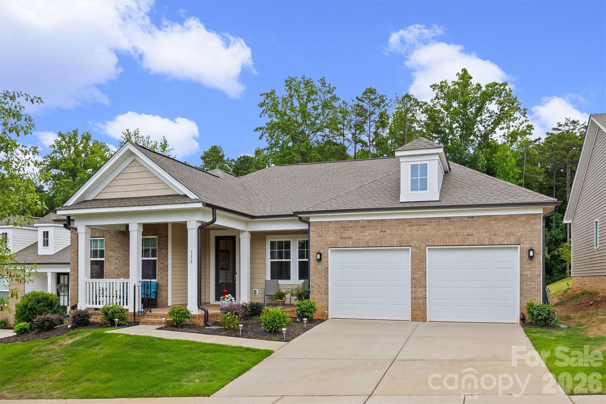 Charming brick-front single-story home with a welcoming front porch and a 3/4 glass front door—bright, move-in ready and low-maintenance. Step inside to vinyl plank flooring through the living areas and carpeted bedrooms. The open-concept interior is flooded with natural light from abundant windows and showcases modern finishes, designer light fixtures, and a trey-ceiling great room.

The gourmet kitchen is a showstopper featuring a center island, beautiful stained cabinets, tasteful granite counters, gas cooktop with direct-vent hood, built-in wall oven and microwave, plus a large pantry. The adjacent dining area overlooks a serene backyard—perfect for meals and entertaining. A screened porch and open patio offer relaxing outdoor living after a long day.

The spacious primary suite includes a walk-in closet and a spa-like en suite with a large dual-sink vanity, tile shower and private water closet. Convenient laundry access connects to both the primary bedroom and the main hallway. The third bedroom is currently used as a den - it does not have a closet but has space to easily add one. Finished 2-car garage with epoxy floor completes the package.

Located minutes from I-77, shopping and restaurants with an easy commute to Uptown Charlotte—this home combines style, comfort and convenience. Schedule your tour today.