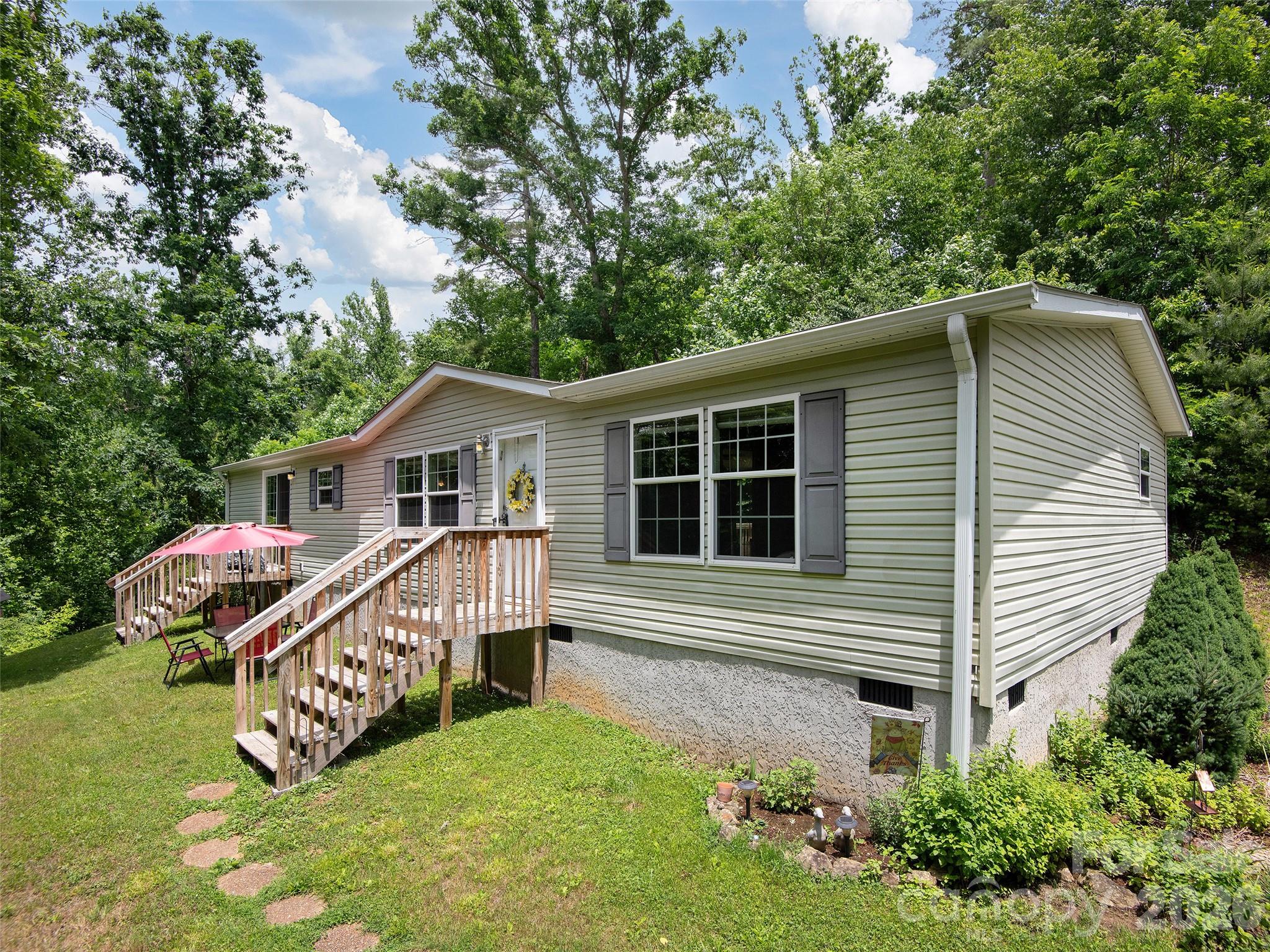 Single-level living on 2.71 acres with room to breathe, garden, and enjoy the relaxed feel of country life. This 3-bedroom, 2-bath home offers a functional split floor plan with the private primary suite on one side and two additional bedrooms plus a full bath on the other. The spacious kitchen features a large island ideal for meal prep and entertaining, and flows easily to the dining area and main living spaces. A dedicated laundry room adds everyday convenience. The private primary suite features a walk-in closet and an ensuite bathroom with a relaxing soaking tub and separate walk-in shower. Two sliding glass doors and two additional entry doors bring in great natural light and connect you seamlessly to the outdoors. Gently laying land provides plenty of usable space for a garden, pets, play, or future projects. Located in the welcoming Fines Creek community, you’ll appreciate peaceful surroundings and the simple charm of country living, all while being an easy drive to nearby Waynesville and I-40 access.