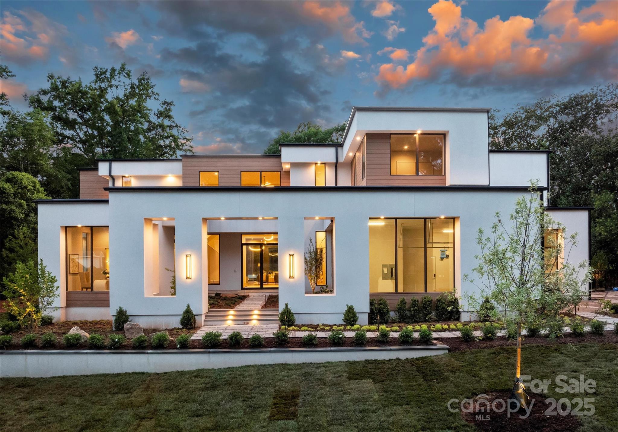 Newly completed & nestled on .84 acres in Foxcroft, is a stunning new Mills Eloge construction blending California modernism w/ Southern warmth. This sanctuary boasts thoughtful design & uncompromising quality. Highlights include a courtyard entrance, light-filled interiors,12-foot ceilings & walls of glass, seamless indoor/outdoor living w/ automated stackable doors to a private pool, spa & covered porch. Curated details like reeded white oak ceiling & wall treatments. The layout features a kitchen & a full caterers kitchen with Wolf & Sub-Zero appliances, a main-floor primary suite w/ separate his & her water closets, a private office, & flexible & luxurious living spaces. The 2nd level offers spacious en-suite bedrooms, a living room w/ wet bar, & two additional flex spaces. Luxury touches include a 4-car garage with enough height for a lift, a covered porch w/ automatic screens, elevator-ready, whole-home automation pre-wire, & custom closets. Tranquility in the heart of Charlotte.