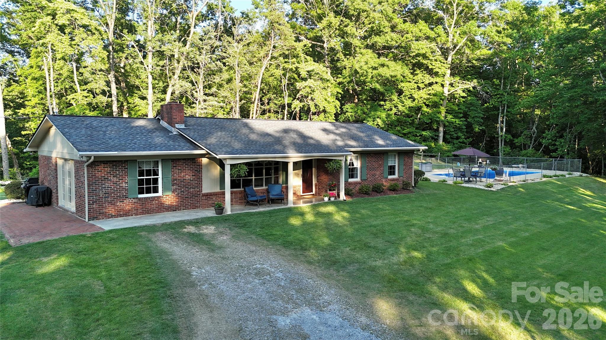 Immaculate one-owner brick ranch offering comfortable one-level living on 3± unrestricted acres at the end of a private road. Bordering approximately 840 acres of conservation land, this rare property offers unmatched privacy, peaceful surroundings, abundant wildlife, and the feeling of having your own mountain retreat.

Inside, you'll find a thoughtfully designed floor plan featuring 3 bedrooms, 2 bathrooms, a spacious den, inviting family room, formal dining room, an expansive kitchen, and a separate laundry room. Beautiful hardwood floors run throughout the main living areas, complemented by tile in the kitchen and bathrooms and carpet in two of the bedrooms. Updated windows fill the home with natural light throughout. The primary bathroom features a tub/shower combination, while the second bathroom offers a modern walk-in shower and a private exterior entrance, providing convenient access from the pool without having to walk through the home.

The spacious kitchen comes fully equipped with a stove, dishwasher, built-in microwave, side-by-side stainless steel refrigerator, and an additional wall oven. The washer and dryer also convey, making this home truly move-in ready.

Designed for year-round comfort, the home features three heating options: a Buck Stove wood-burning fireplace, a Buck Stove vented gas log fireplace, and a heat pump with central air, providing both efficiency and flexibility throughout the seasons. Additional features include generator wiring and a private well.

Step outside and enjoy your own private backyard oasis. The fenced 18' x 36' in-ground pool has been extensively updated, with a new liner, pump, filter, and steps installed in May 2026, offering peace of mind and years of enjoyment. The meticulously maintained 100% Zoysia lawn provides beautiful, golf course-like curb appeal, while the detached two-story, two-car garage offers abundant storage, workshop space, or the opportunity to create additional finished living space.

Whether you're relaxing by the pool, watching wildlife from the porch, or enjoying the quiet surroundings, this property offers the peaceful lifestyle that's becoming increasingly difficult to find. Despite its secluded setting, you're just a short drive from Downtown Marion, Lake James, the Blue Ridge Parkway, Asheville, Hickory, Boone, the High Country ski slopes, Linville Falls Winery, Linville Gorge Wilderness Area, and the Switzerland Inn & Spa.

A truly one-of-a-kind property that combines quality construction, thoughtful updates, exceptional privacy, and an unbeatable Western North Carolina location.