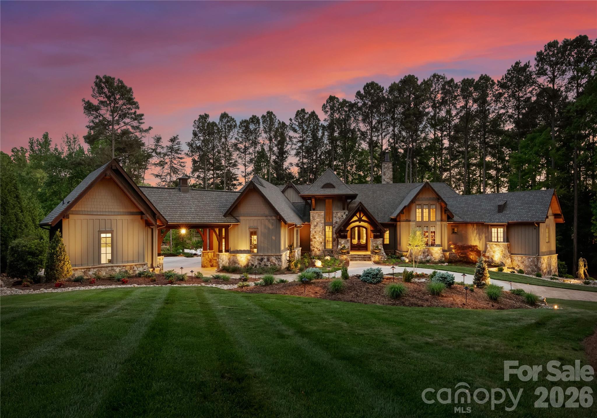 LIFE AT THE POINT, REIMAGINED
One of the largest lots in The Point on Lake Norman. Designed by architect Christopher Phelps, this American Craftsman Lodge Home delivers what few properties can: true waterfront privacy, forested seclusion, and architectural integrity that simply isn’t replicated in new construction.
Carolina Timberworks custom wood arches frame a soaring 21-foot ceiling, complemented by wide-plank hickory hardwoods, Clark Hall iron entry doors, Pella windows, Hardie board siding, and Clopay garage.
Two kitchens. Zero compromises.
The main kitchen features a twelve-foot granite island, dual Sub-Zero refrigerators, Wolf range and wall ovens, Bosch and Miele dishwashers, Sub-Zero wine storage, and a full butler’s pantry. The downstairs bar adds dual Sub-Zero wine refrigerators, Thermador beverage drawers, a Perlick ice maker, kegerator, and Miele dishwasher — built to entertain at scale.
A private owner’s wing. Suites for everyone else.
The primary suite occupies its own main-level wing with heated floors, dual closets, and an adjacent home office. An additional en-suite bedroom offers main-level guest privacy. The lower level adds three more guest suites, a bar and entertainment room, a temperature-controlled wine room, and an exercise studio with dry sauna.
Lake living, earned.
The screened lakeside porch — heated and anchored by an outdoor fireplace — opens to direct lake access. Deeded boat slip, thirteen-zone irrigation, and estate-standard grounds complete the picture.
The garage that goes beyond parking.
The home includes an attached three-car garage plus a separate two-car garage beneath a Porte-cochère — offering flexible space currently configured for a golf simulator and workshop.
Systems worthy of the architecture.
Geothermal heat pump, seven-zone HVAC, Generac whole-home generator, Control4 automation, Sonance audio, commercial lightning protection, whole-house water filtration, and an oversized motor court.
Private showings by appointment only.