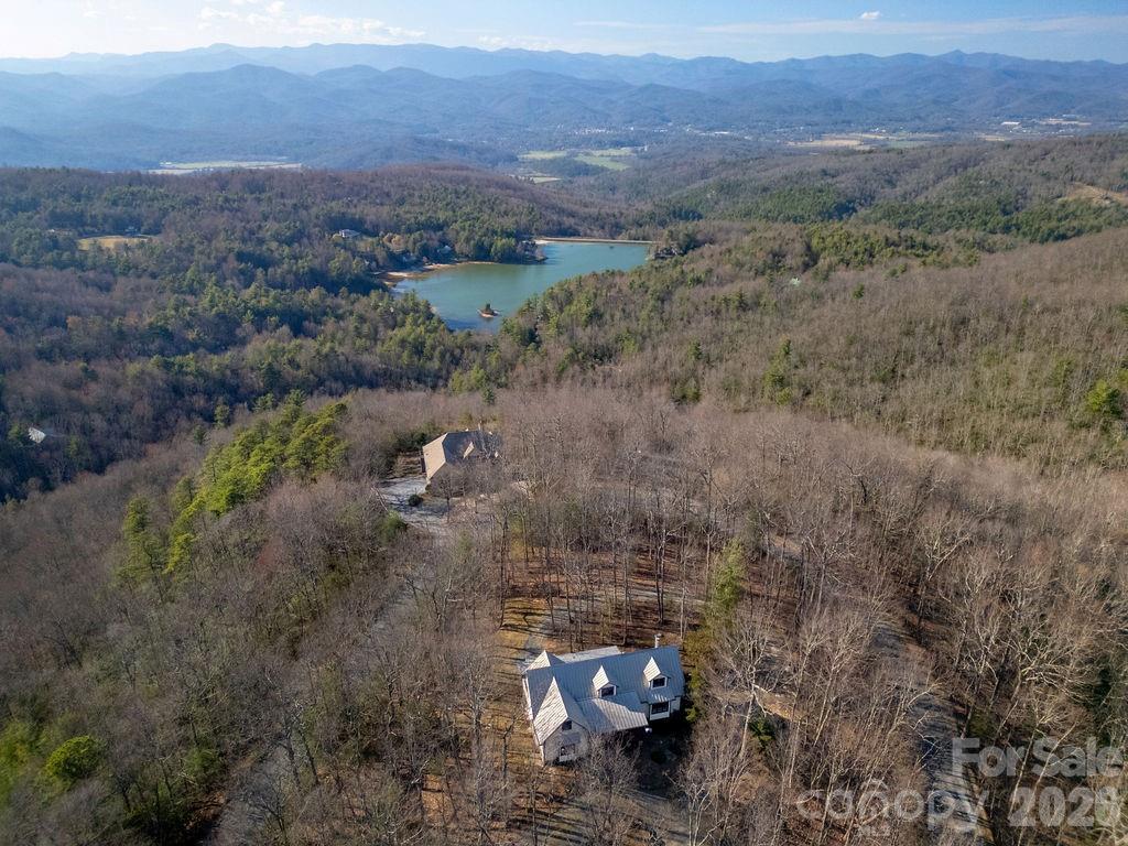 CHECK OUT THE VIDEO -- Welcome to 40 Walnut Ridge Circle, a custom-built mountain retreat offering 3 bedrooms and 3 baths on nearly 5 acres of private, wooded land at the top of Walnut Ridge in the sought-after Eagle Lake community. This exceptional home combines quality craftsmanship, natural beauty, and thoughtful design in a peaceful, elevated setting.

Step inside to a stunning great room with cathedral ceilings and floor-to-ceiling windows, filling the space with natural light and showcasing the surrounding landscape. A stone fireplace creates a warm focal point, perfect for cozy evenings. The home features Australian cypress flooring, custom cherry cabinetry in the kitchen and primary suite, and maple cabinetry throughout the rest of the home, highlighting the attention to detail and high-end finishes.

The layout is designed with privacy in mind, offering comfortable separation for guests and family. The upper level includes a spacious family room along with a bonus office/den or additional guest space, providing flexibility for a variety of needs.

The lower level is a true standout, featuring a woodworker’s dream workshop—fully outfitted and available for purchase with tools and equipment—along with a separate garage for additional storage or workspace.

Located within the Eagle Lake community, residents enjoy access to a 32-acre private lake, ideal for swimming, fishing, boating and beach access, all while being just minutes from downtown Brevard, DuPont State Forest, Pisgah National Forest, and a short drive to the Asheville Regional Airport.

With its combination of privacy, craftsmanship, and access to both nature and community amenities, 40 Walnut Ridge Circle offers a rare opportunity to experience the best of mountain living.