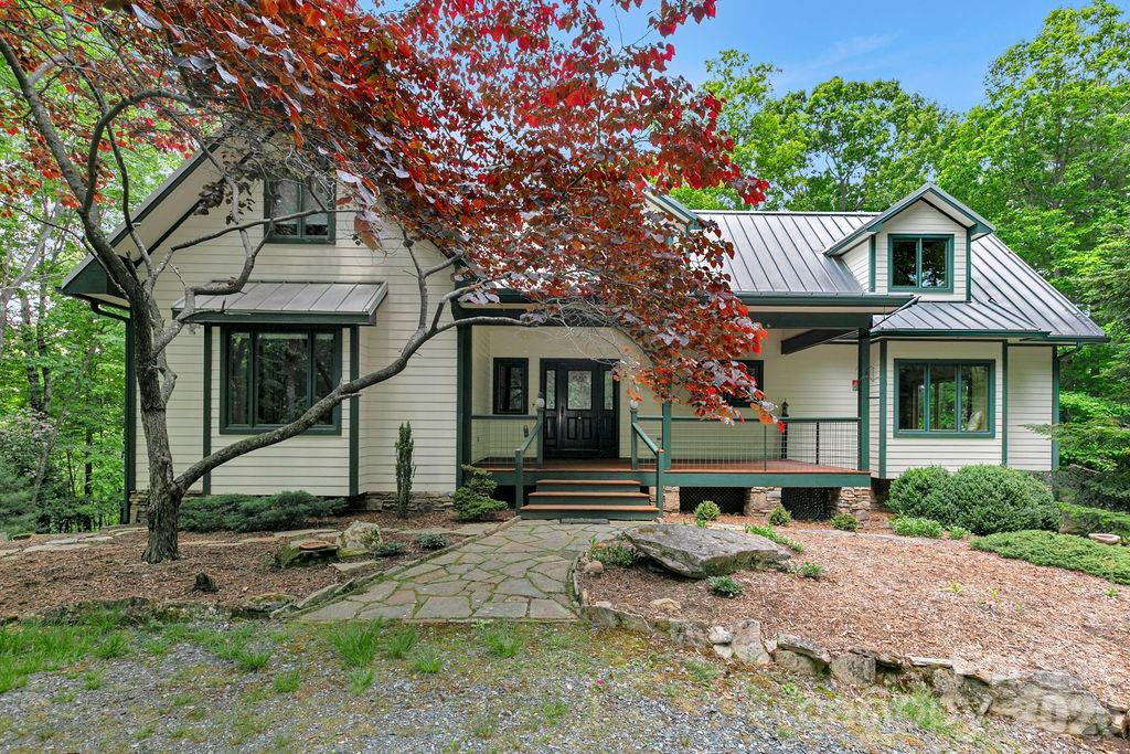 CHECK OUT THE VIDEO -- Welcome to 40 Walnut Ridge Circle, a custom-built mountain retreat offering 3 bedrooms and 3 baths on nearly 5 acres of private, wooded land at the top of Walnut Ridge in the sought-after Eagle Lake community. This exceptional home combines quality craftsmanship, natural beauty, and thoughtful design in a peaceful, elevated setting.

Step inside to a stunning great room with cathedral ceilings and floor-to-ceiling windows, filling the space with natural light and showcasing the surrounding landscape. A stone fireplace creates a warm focal point, perfect for cozy evenings. The home features Australian cypress flooring, custom cherry cabinetry in the kitchen and primary suite, and maple cabinetry throughout the rest of the home, highlighting the attention to detail and high-end finishes.

The layout is designed with privacy in mind, offering comfortable separation for guests and family. The upper level includes a spacious family room along with a bonus office/den or additional guest space, providing flexibility for a variety of needs.

The lower level is a true standout, featuring a woodworker’s dream workshop—fully outfitted and available for purchase with tools and equipment—along with a separate garage for additional storage or workspace.

Located within the Eagle Lake community, residents enjoy access to a 32-acre private lake, ideal for swimming, fishing, boating and beach access, all while being just minutes from downtown Brevard, DuPont State Forest, Pisgah National Forest, and a short drive to the Asheville Regional Airport.

With its combination of privacy, craftsmanship, and access to both nature and community amenities, 40 Walnut Ridge Circle offers a rare opportunity to experience the best of mountain living.