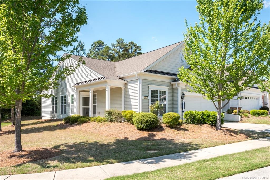 Popular Muirfield Villa in a great location- walking distance to the shopping center! Enjoy amazing lake & wooded views from the screened porch & private backyard with 6ft. privacy partition. Foyer leads to library with wainscoting & crown molding detail. Open great room w/ ceiling fan and fireplace is perfect for entertaining. Kitchen w/ stainless steel appliances, island, and dining nook w/ great natural lighting. Experience easy living in this 55+ active adult community with amenities galore.