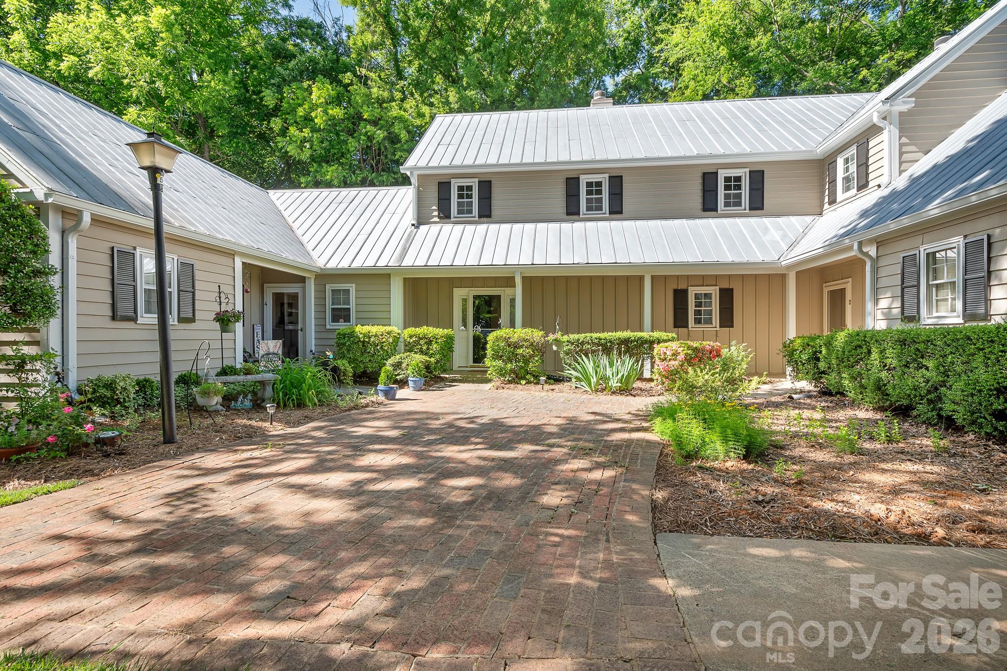 Great Location!. Renovated Primary Bathroom, Updated Secondary Bathrooms. Enjoy the perfect blend of privacy and prime location in a picturesque neighborhood filled with tree-lined streets and a welcoming community pool. This delightful cottage-style condo features a secluded patio surrounded by a privacy fence, offering your own outdoor retreat. Nestled in the heart of Sedgefield, you are just moments from South End, Park Road, and Dilworth, with coffee shops, restaurants, and parks all within easy reach. Step inside to discover a living room brimming with character, complete with a cozy fireplace and elegant French doors that open to the backyard patio and fresh paint throughout. The open kitchen flows seamlessly into the dining area, with space for a breakfast bar and direct access to the patio through another set of French doors. An updated half bath graces the main level. Upstairs, unwind in the primary bedroom, where charming doors overlook the patio, and indulge in the newly renovated primary bath with a new luxurious shower, vanity, sink, & mirrors. The conveniently located hallway washer and dryer serve both bedrooms. The second bedroom offers its own en-suite bathroom, updated vanity, sink and mirror and a walk-in closet, with more charming doors framing views of the patio. The patio also has an outside storage area. Enjoy the treelined walk to the neighborhood pool.  The delightful, charming condo won't last long, it's just waiting for you to enjoy.