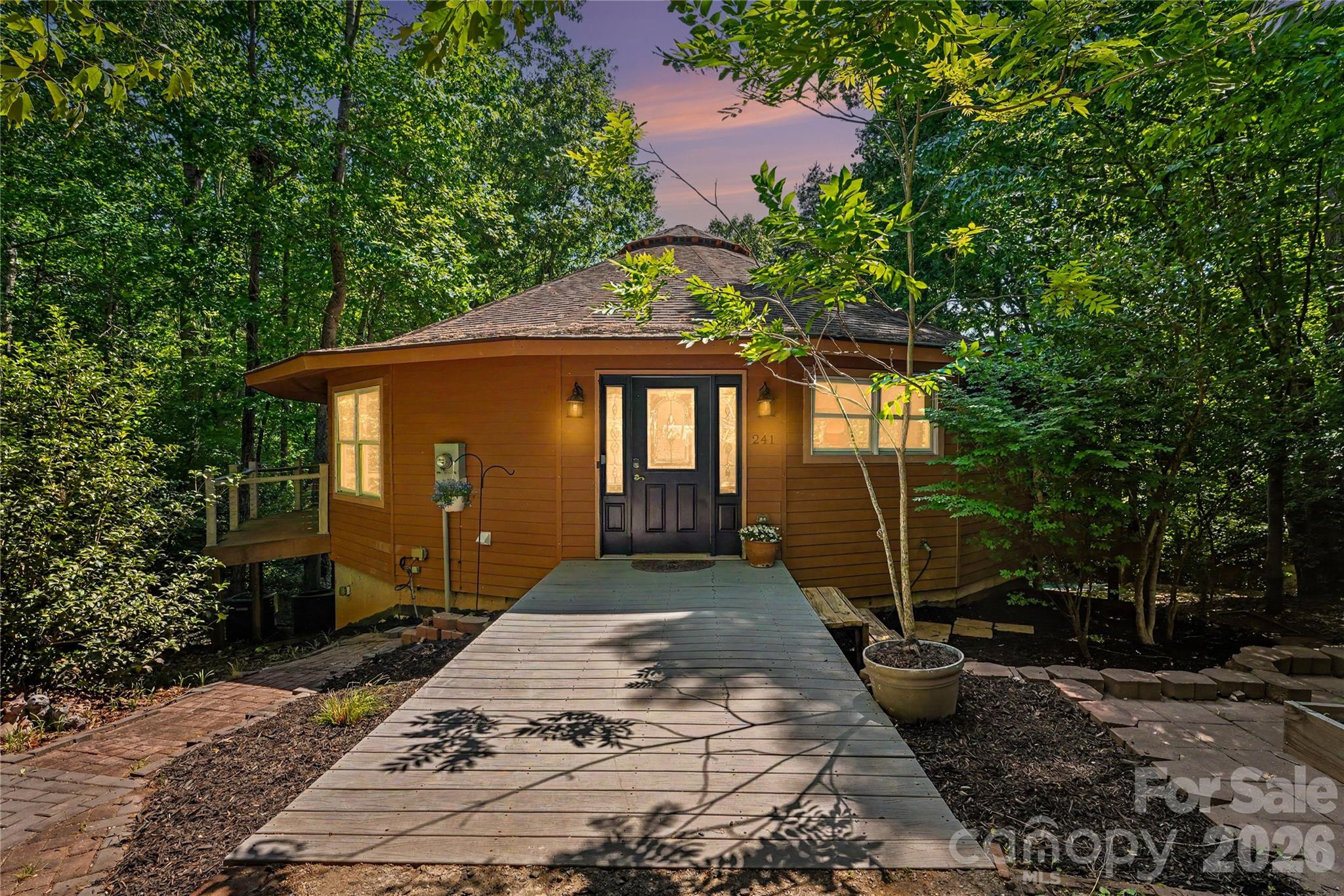Nestled in a private, wooded 1-acre lot with seasonal water views, lake access, and no HOA, this beautifully updated 4BR/3BA retreat offers a rare combination of flexibility, privacy, and value along the Lake Norman corridor. Complete with access to a community boat launch and dock, it's designed for those who appreciate both recreation and tranquility.
The main level showcases elevated renovated living spaces, an elevated kitchen with expanded island storage and pantry, a stunning new primary bath, updated secondary bath, and expansive windows that invite the natural surroundings inside. A private balcony off the second bedroom provides a peaceful place to enjoy morning coffee or evening sunsets. Recent improvements, including a separate lower-level HVAC system, new well pump, and expanded septic capacity, provide added confidence and convenience.
The fully finished lower level expands the home's versatility with a second full kitchen, two additional bedrooms, full bath, and dedicated climate control, creating ideal space for multigenerational living, extended guests, or flexible lifestyle needs.
Outdoor living is equally impressive, with multiple spaces for entertaining and relaxing amid mature trees, natural privacy, and a park-like front yard setting. Two driveways, including one that wraps to the side of the property, offer added functionality and convenience.
Whether you're launching the boat for a sunset cruise, hosting family and friends, or simply enjoying the quiet lake-adjacent setting, this property delivers a lifestyle that feels miles away from it all while remaining convenient to  Troutman, Statesville, and Mooresville.
Thoughtfully priced and offering exceptional value relative to recent market analysis, this turnkey lake-access property close to LKN State Park presents a unique opportunity for buyers seeking versatility, character, and a relaxed Lake Norman lifestyle. Agent is owner