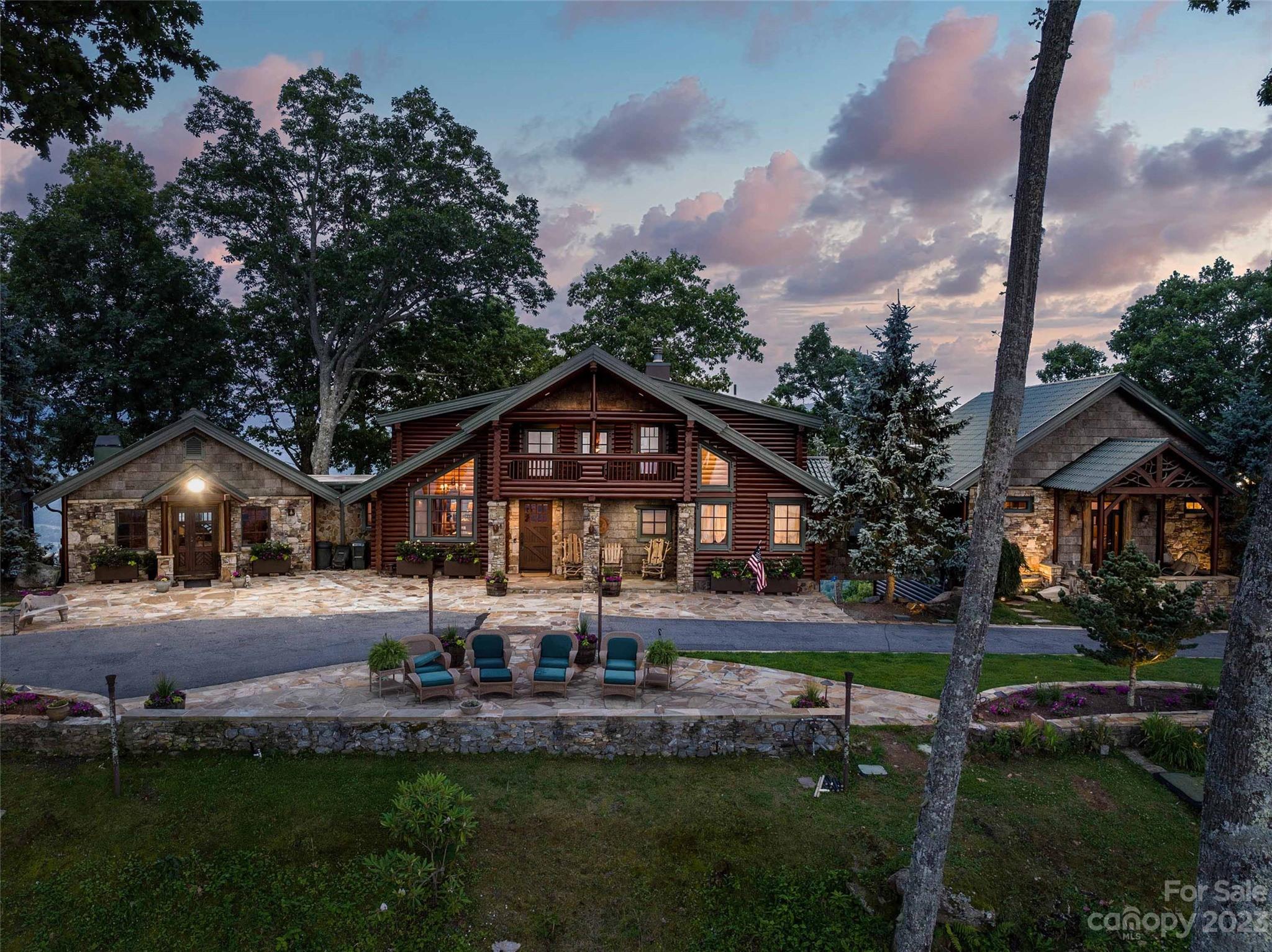 Expansive mountain top estate perfectly-positioned in a peaceful setting. Drive through the grand gate at the entrance to a stunningly crafted log home with breathtaking 360 degree mountain views overlooking the WNC mountains. This 18+ acre estate is surrounded by gorgeous landscaping and natural woods. The main entrance of the home boasts an open floor plan with large windows that bathe the space in natural light. The grand main level has 2 floor-to-ceiling stacked river stone fireplaces, a private library/study, separate den, and butlers pantry. The lower level is perfect for visiting guests with private space, private deck, family room, fireplace, jacuzzi/hot tub, sauna & outdoor shower. The upper level includes a large bedroom/bath and a loft area for a peaceful retreat or a quiet home office. The outdoor area provides year round entertaining w/covered pavilion with an outdoor kitchen w/ appliances & fireplace, 2 large stone waterfalls, and enclosed greenhouse/she-shed.