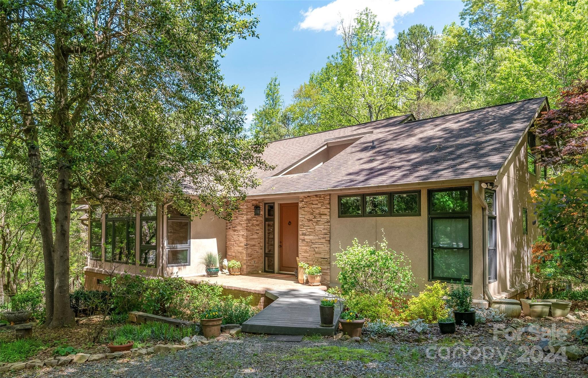 Welcome to a hidden oasis on 1.19 acres, where mid-century modern design seamlessly blends with nature. From the moment you step into the circular entrance with its skylight, you know you are home.

Experience the awe of the 2-story great room, bathed in natural light from floor-to-ceiling windows, offering breathtaking views. The centrally located chef's kitchen provides panoramic views that inspire culinary creativity.

Imagine starting your day in the sunroom/breakfast nook, surrounded by windows that invite the beauty of the outdoors in. Retreat to the primary bedroom, with a screened-in porch and a custom walk-in closet for ultimate relaxation.

Discover the charm of Bedroom 3, featuring a spiral staircase leading to a loft with stunning views, perfect for a studio or office. The lower level surprises with a 2nd living area, complete with a kitchen and full bath.

Just minutes from Ballantyne, this home offers the tranquility of nature with the convenience of city life.