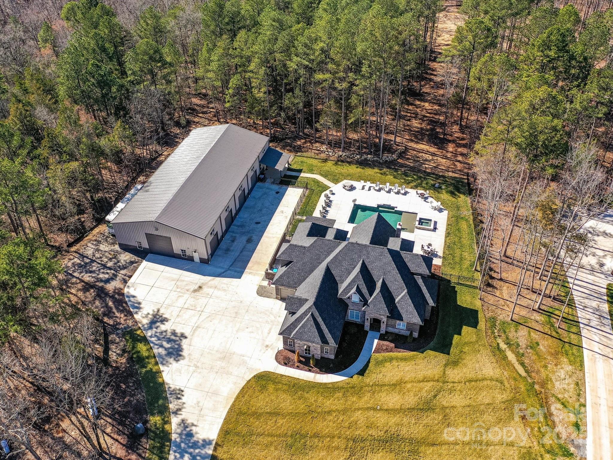 Welcome to The Homestead, a one-of-a-kind French Country masterpiece in Cabarrus County! This brand-new gem features 4 beds and 5 baths, nestled on 4 acres, just minutes from Afton Village and I-85. Enjoy unparalleled privacy within a quaint 5-home mini-subdivision with no-HOA. The home boasts a gourmet kitchen with commercial grade appliances and a chef's dream oven, a large primary bath with a walk around shower, and a beautiful wine room with it's own cooling system. 
Upstairs has 3 bedrooms and 3 private baths & you will find a 12-seat 9.2.2 surround sound theatre room. The property boasts a heated in-ground pool and jacuzzi and a 4,688 sq ft, 4-bay insulated metal building, complete with oversized RV garage door and an indoor pickleball/ basketball court. On the back of the building, you will find an additional 1,600 sq ft in-law suite with its own entrance. there is an additional room on the main level that could serve as a bedroom.