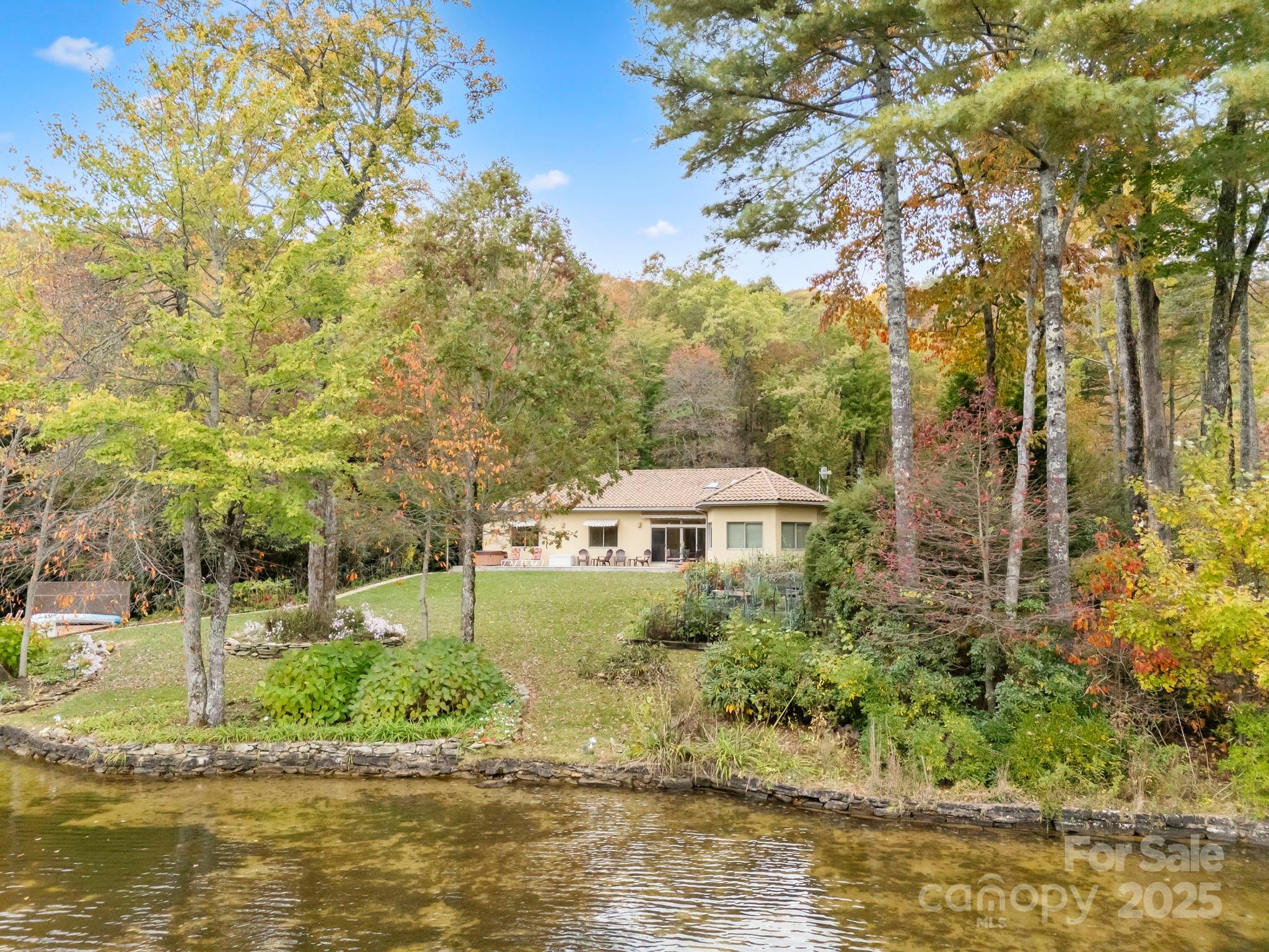 This waterfront home is located on the banks of the most picturesque shore of Lake
Toxaway. The stunning 4-bedroom, 4.5 bath residence offers the perfect blend of comfort, privacy, and lakeside living all on one convenient level.The main portion of the home features a 2 car garage(22x26), 2 bedrooms and 2 baths while a private guest suite adds an additional 2 bedrooms, 2 baths, and a separate living room ideal for family and friends or multi-generational living and cork floors in the majority of the home. Enjoy breathtaking lake views from every room, with a level lot leading directly to the water and your own private dock. The circular drive and gated entrance provide an added sense of privacy while the spacious covered patio welcomes you to relax or entertain in style any time of day. Outdoor living shines here with a hot tub on the front patio, a fire pit by the lake for cozy evenings, and plenty of space for gardening and outdoor recreation. Built with insulated concrete formed (ICF) walls, this home offers exceptional stability, energy efficiency, and aesthetic appeal. Situated in a quiet cove, you’ll appreciate the peaceful setting and deep water access perfect for swimming, boating, and lakeside enjoyment. Homes like this are a rare find on Lake Toxaway. Take advantage of the opportunity to own a generational property that is full of charm, character and lots of mountain air. Call today to schedule your private showing.