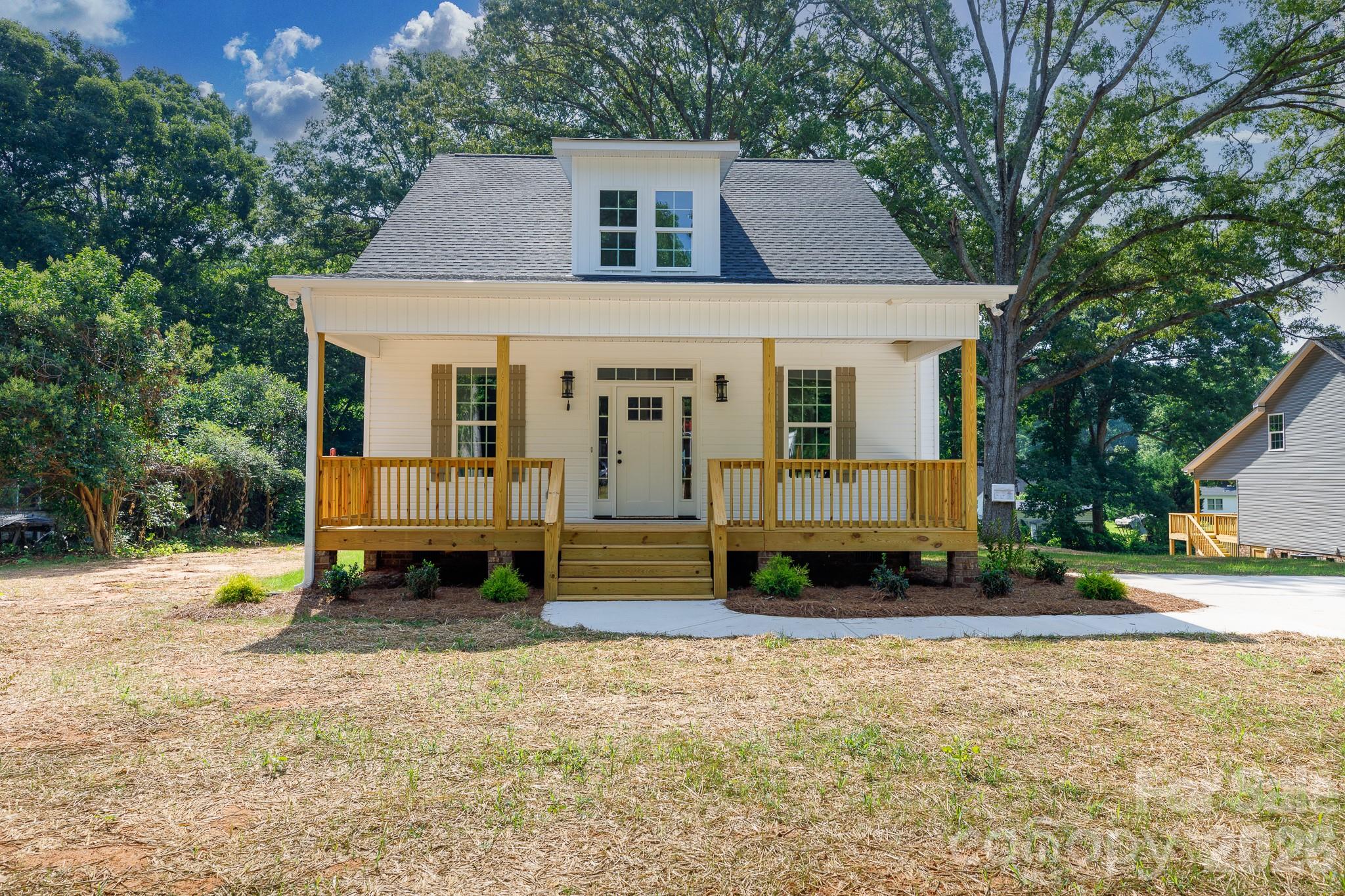 Welcome home to this beautiful new construction situated on a spacious 0.54-acre lot with the added benefit of no city taxes. From the moment you arrive, the large front porch invites you to sit back, relax, and take in the quiet surroundings. Inside, the bright and open floor plan flows seamlessly across durable luxury vinyl plank flooring throughout the main level, creating an ideal layout for both everyday living and easy entertaining. The heart of the home is a stunning kitchen equipped with quartz countertops, a functional center island, a breakfast bar, and a dedicated pantry, all opening directly to the dining area. Retreat to the main-level primary suite, a private oasis featuring a generous walk-in closet, dual vanities, and a beautifully tiled shower. Step outside to the rear covered deck to enjoy peaceful morning coffee or weekend cookouts overlooking your backyard. Offering four bedrooms and two and a half baths, it is a space designed to effortlessly accommodate both busy mornings and quiet, relaxing weekends.