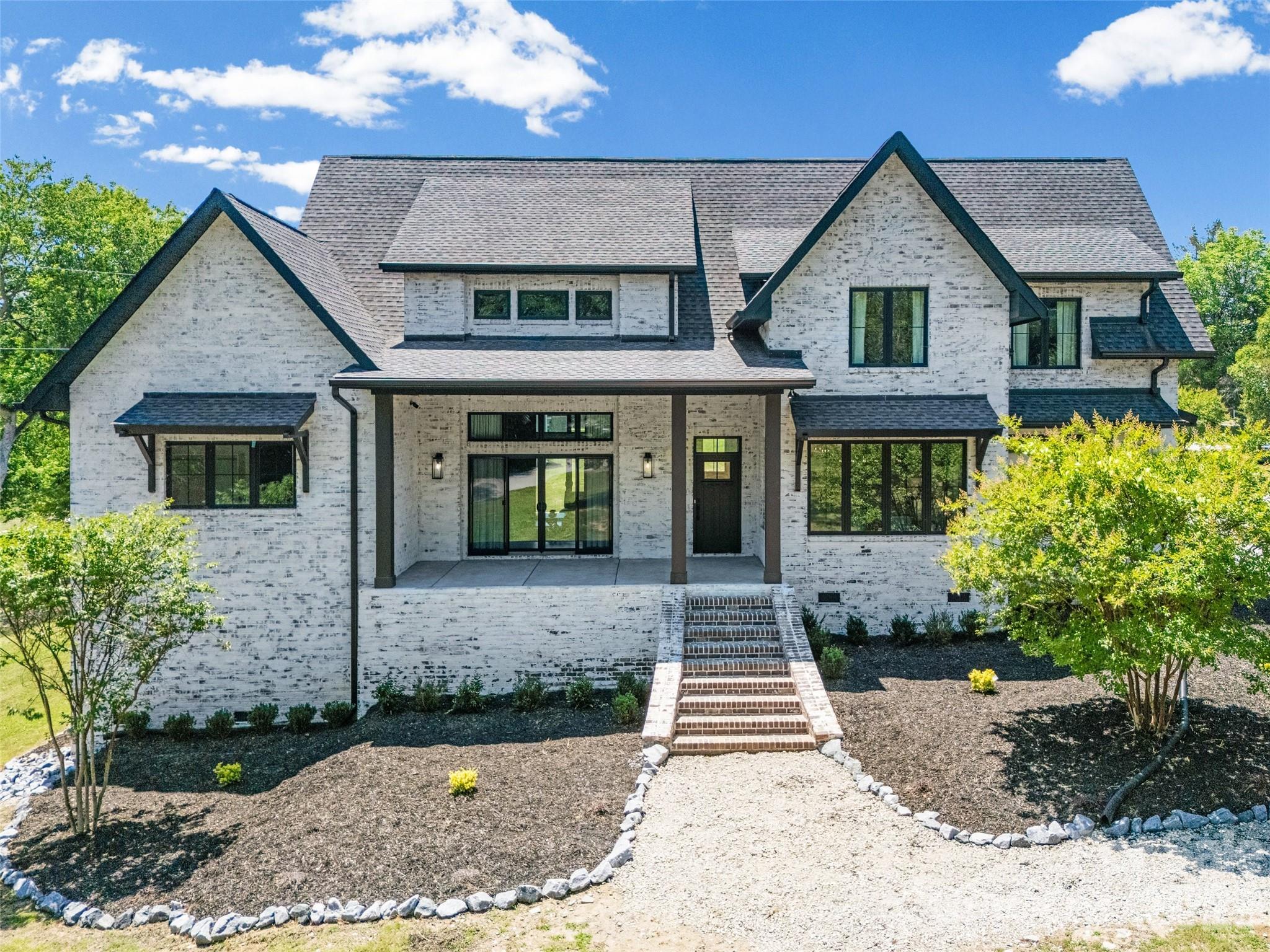 Stunning custom-built modern European farmhouse situated on 1.7 acres of land in the heart of Lake Wylie, offering luxury finishes and exceptional craftsmanship throughout. This 4-bedroom, 4.5-bath home features striking German smear brick, Andersen casement windows and doors, rich hickory flooring, soaring ceilings, coffered tray ceiling, modern gas fireplace and an open-concept layout ideal for entertaining.

The chefs kitchen showcases quartz countertops, custom cabinetry, oversized island seating, stainless steel appliances, and a walk-in pantry. The spacious main-level primary suite offers a spa-inspired bath with marble tile flooring, a freestanding soaking tub, and a Euro-style slate shower with dual rainfall heads and a floating teak bench.

Additional highlights include a fully dedicated theater room designed for the ultimate cinematic experience, dual first and second story laundry rooms, continuous hot water, full security system, stamped concrete, natural gas outdoor grill hookup, wiring for a hot tub.

The walk-in attic offers excellent potential to be finished for additional living space in the future. The oversized three-car garage is wired for a vehicle lift, creating the perfect setup for car enthusiasts, workshop space, or additional storage. This home was built with 2x6 framing and thoughtfully designed with luxury, comfort, and functionality in mind.

Located just minutes from shopping, restaurants, everyday conveniences, and access to Lake Wylie.
