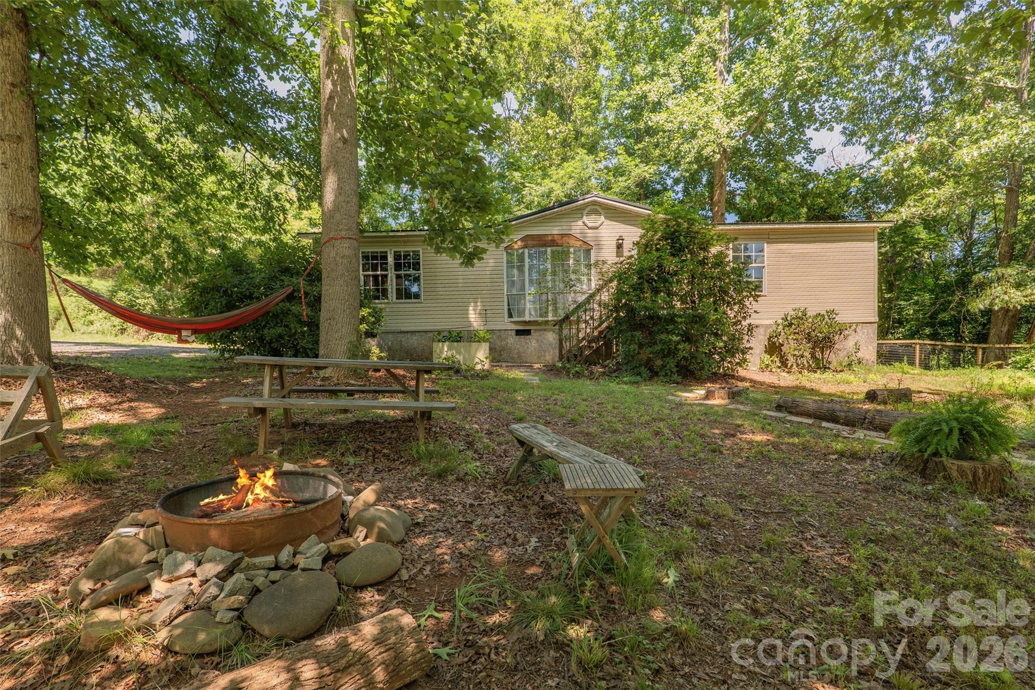 Retreat to peaceful mountain living on a naturalized .78-acre parcel bordered by woodland and the beauty of the Blue Ridge. This well-maintained 3-bedroom, 2-bath home features a desirable split-bedroom floor plan, updated kitchen and baths, whole-house water filtration system, upgraded well pump, new HVAC, metal roof and all appliances with no HOA fees. The property also offers a fenced side yard, shed and fully powered workshop/garage with insulated storage room and additional utility appliances, providing excellent areas for projects, storage, gardening or hobbies. Explore local nearby amenities like the Farm Heritage Trail, Addison Farms Vineyard  and Hope for Horses Sanctuary or easily access all things Asheville about 15 miles away. When you're ready for a peaceful haven to call home, Turkey Creek Terrace delivers privacy, thoughtful updates and abundant natural surroundings for full-time residence, seasonal getaway, or investment potential.