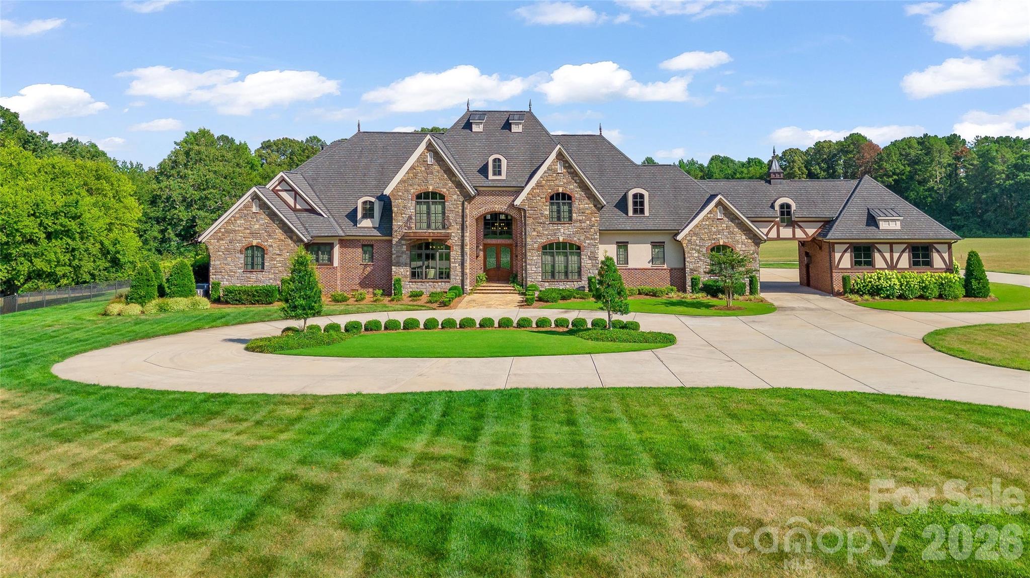 There are properties that command a price, and there are properties that justify one. 3200 Beaty Road does both.

Set on 54.93 private acres in Gaston County, outside city limits and bordering the protected edge of the Catawba Land Conservancy, this 2020 custom estate represents one of the most compelling value propositions in the greater Charlotte luxury market. To replicate the home alone at today's construction costs would exceed $3.4 million. Add the land, the barn, and the infrastructure, and the replacement cost climbs past $6 million. It is offered at $5,450,000.

Bob Rouse Custom Homes delivered 8,174 square feet of meticulously crafted living space with a level of finish that is immediately apparent from the gated entry forward. A porte-cochere announces the arrival sequence. Inside, the residence is appointed with the intention and material quality expected of a home of this caliber, designed for full-time luxury living, not weekend approximation.

The pool and outdoor kitchen extend the living environment seamlessly into the landscape. The 2,585-square-foot barn and carriage house, equipped with four stalls, serves the equestrian buyer as readily as it does the car collector or the working farm operation. The acreage itself is the kind of land that disappears from this corridor: deep, private, and productive, with a stocked pond, cleared vehicle and ATV trails throughout, and a level of pasturescaping that is rare for the area. Situated just outside city limits, the property allows hunting, sporting arms, and clays — a combination that is increasingly difficult to find this close to Charlotte. This is land that earns its acreage.

Twenty minutes to Charlotte Douglas. Minutes from Gastonia Country Club, Gaston Day School, and Gaston Airport. Country club polish meets country life.

For the right buyer, this is equally a legacy hold. As Charlotte's growth corridor continues its westward march through Gaston County, 54.93 acres on this address carries long-term exit strategy potential that few luxury estates can offer. The lifestyle is immediate. The upside is patient.

This is a sportsman's paradise with the grace of a custom gated estate, tailored for the buyer who recognizes what can't be found twice.