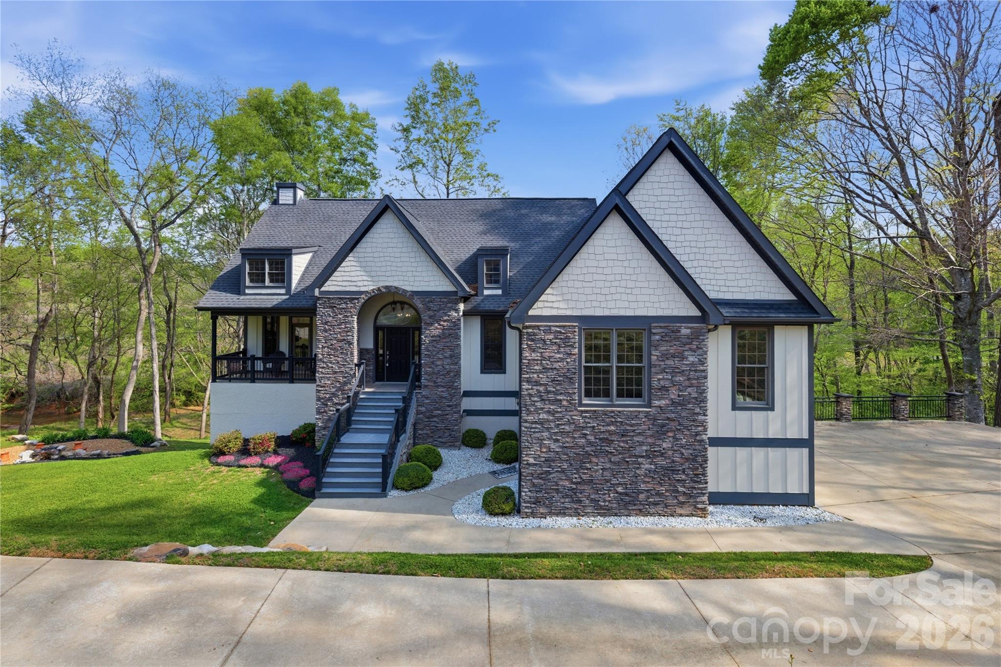 Tucked along White Oak Creek in the gated community of Vista at The Riverbank, this inviting mountain retreat is designed for those who value space, comfort, and connection to nature. From the moment you step inside, the open-concept main level creates a bright, expansive feel, with seamless flow between the living, dining, and kitchen areas—perfect for both everyday living and entertaining. The oversized primary suite offers a true retreat with generous space to unwind and relax. The home truly shines when it comes to indoor-outdoor living, featuring abundant deck space on both levels along with a screened porch, creating multiple areas to gather, entertain, or simply take in the peaceful surroundings. Just steps away, a beautifully designed fire pit invites evenings under the stars, where you can listen to the gentle sounds of the creek while roasting marshmallows and enjoying the serene setting. The finished lower level offers exceptional additional living space, complete with a spacious family room and large bedrooms, making it ideal for guests, multi-generational living, or extended stays. With ample parking and thoughtfully designed outdoor areas, this home was built with entertaining in mind. The property has been beautifully landscaped and meticulously maintained, reflecting true pride of ownership. Located in a quiet, walkable gated community just minutes from the Tryon International Equestrian Center, and conveniently positioned less than 20 minutes to Hendersonville, 30 minutes to Asheville, and approximately 45 minutes to both Charlotte and Downtown Greenville, this home offers the perfect balance of privacy, accessibility, and lifestyle.