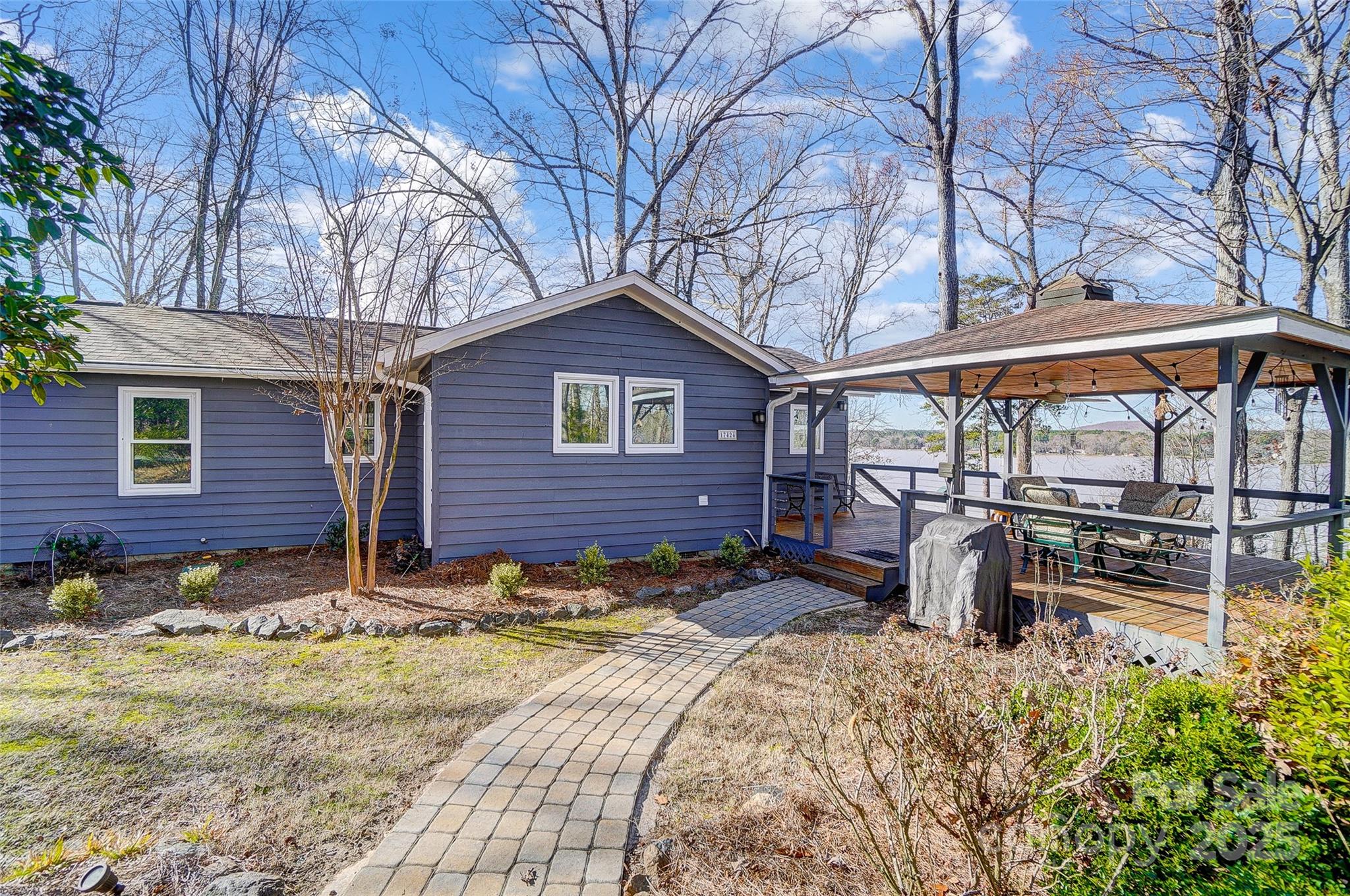 Designed for lake living at its best, this classic waterfront home offers sweeping main-channel views, lush landscaping, and mature hardwood trees. Ideal as a weekend retreat or full-time residence, this beautifully updated one-level home is filled with character and charm. Highlights include an open floor plan, vaulted wood-paneled ceilings, hardwood floors, and a lake-facing great room that captures stunning water views. The updated kitchen is perfect for entertaining, featuring stainless steel appliances, a center island, and abundant counter space to inspire your inner chef. Updated bathrooms add comfort and style throughout the home. Outdoor living shines with a huge wraparound deck, covered porch, multiple lakeside decks, and a brand-new covered dock with boat lift—perfect for entertaining, relaxing, or soaking in the scenery. Situated on the main channel of Lake Wylie, the property offers excellent access for boating, water sports, and fishing. Enjoy a peaceful “away-from-it-all” lifestyle while remaining just minutes from shopping, dining, Uptown Charlotte, and the airport.