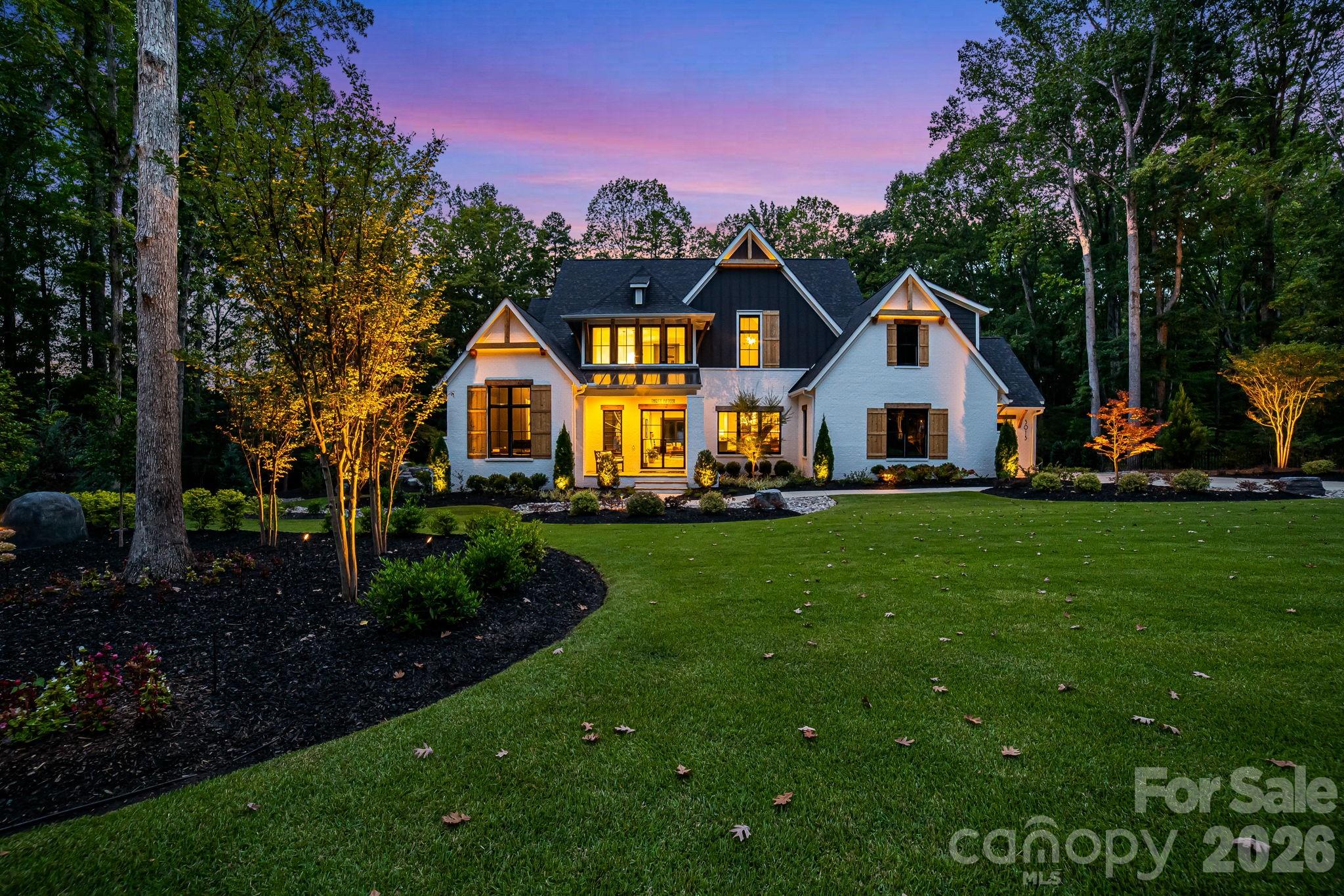 Experience unmatched privacy and modern luxury in this fully custom 2023 estate, perfectly situated on over 3.4 acres in Maple Grove, a boutique six-lot subdivision. From the moment you arrive, the gated entry with brick columns and sweeping front lawn framed by manicured landscaping create a commanding first impression.
The home’s thoughtful design blends sophistication and comfort with soaring vaulted and beamed ceilings, custom millwork, and designer lighting throughout. The chef’s kitchen showcases natural Vancouver Quartzite with a double-edge island, 6-burner range with griddle and hearth oven, pot filler, hidden walk-in pantry and outlets, complemented by a separate scullery with a full second kitchen, Italian handmade backsplash tile, and abundant storage. Pocket doors add privacy to multiple spaces including the library/media room and guest suites.
Retreat to the serene primary suite with spa-inspired bath, custom closets, and marble finishes. Additional highlights include glazed Italian porcelain tile baths, custom built-ins, herringbone wood floors, and three Monogram wine/beverage fridges across the bar, library/media room, and outdoor kitchen. Outdoor living takes center stage with a resort-style pool and spa, expansive veranda with retractable screen, fire pit, and an inspired backyard retreat featuring a flowing river stream, tiered putting green, and dramatic landscape lighting. Extensive drainage improvements further enhance the property’s functionality and value. Backing to Fisher Farm Park and the Davidson Greenway, this private estate combines natural beauty, luxury finishes, and exceptional craftsmanship in one extraordinary package!
