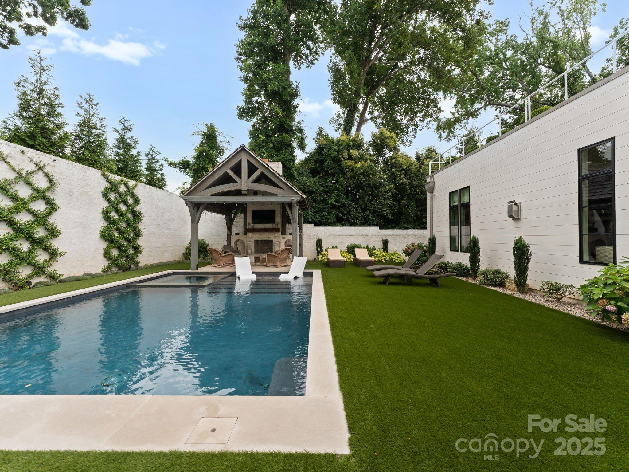 Kenwood Sharon Lane is an exclusive enclave of 10 custom homes developed by Jim Gross, designed by Don Duffy and constructed by Thomasson Builders. Walls of windows, open inviting floor plan, bright and airy.  This incredible home has a primary on the main with an expansive custom closet and gorgeous spa bath. The upper level offers 4 bedrooms w/ en-suite baths & generous closets, a large family room overlooking the private roof top terrace that is 25' by 29'. Incredible brick enclosed private backyard oasis with a pool, spa, covered veranda w/ a fireplace and built in grilling station, The kitchen has Sub-Zero and Wolf appliances, custom cabinetry, large pantry and a separate scullery. There is a beautiful dining room, office that could also be used as a living room, large family room open to the kitchen and breakfast room, and a large laundry/mud area. Unique opportunity to own a residence in the sought after Foxcroft location, minutes to uptown, Myers Park and Southpark.