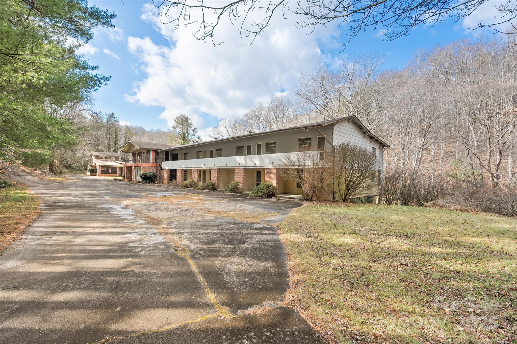 Prime Commercial Opportunity Near the Blue Ridge Parkway

An exceptional opportunity to acquire 2.3± acres of commercially positioned property in one of Western North Carolina’s most heavily traveled and sought-after corridors. Located just minutes, and less than .4 mile, from the Blue Ridge Parkway, this property sits directly along the Great Smoky Mountain Expressway (US-23/74) with 390+ feet of four-lane road frontage, offering unmatched visibility between Waynesville and Sylva. Average daily traffic count is over 24,000, placing it squarely in the path of both local and tourist traffic year-round.

The property is home to the former Balsam Motel, along with a residential house and an additional building, all of which offer substantial potential for updating, repositioning, or complete redevelopment. With its combination of acreage, highway exposure, and proximity to major destinations, the site provides a flexible canvas for a wide range of commercial or investment uses. The motel part of the property (12 units) have sustained lots of water damage due to a long term leak in the roof. The property was last operated as a motel in the early to mid 1990s. The property will take substantial work and vision, but could provide tremendous potential to the next owner.

Visibility and accessibility define the value of this location. Direct access from a major highway, strong daily traffic counts, and immediate proximity to the Blue Ridge Parkway create a setting well suited for businesses or developments that benefit from consistent exposure. Surrounded by mountain views, outdoor recreation, and established regional attractions, the property sits at the crossroads of travel, tourism, and growth.

Whether envisioned as a revitalized motel or boutique lodging destination, a mixed-use or commercial redevelopment, a destination restaurant or retail concept, or a long-term investment in a high-demand mountain corridor, the possibilities here are extensive. Opportunities offering this level of frontage, location, and development flexibility are becoming increasingly rare in Western North Carolina.

Offered at 20826 Great Smoky Mountain Expressway in Waynesville, this property represents a compelling chance to secure a highly visible and versatile site in one of the region’s most desirable and heavily traveled areas.