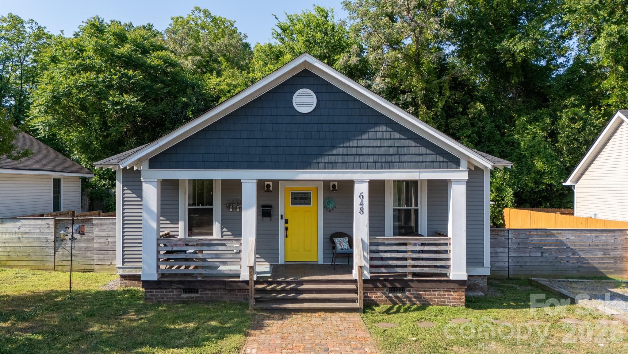 Experience the perfect blend of timeless character and contemporary sophistication in this fully updated, move-in-ready home. Located in the heart of Rock Hill’s coveted historic downtown, this 3-bedroom, 2-bathroom home offers the urban lifestyle you’ve been dreaming of paired with the peace of mind that comes with major recent upgrades, including a new roof and new siding installed in 2024. As you step from the classic covered front porch into the stunning open-concept interior, you are greeted by high ceilings, rich hardwood floors, and elegant crown molding throughout. The chef-inspired kitchen is a true centerpiece, boasting sleek granite countertops, a deep farmhouse sink, stainless steel appliances, and under-cabinet lighting.
The primary suite serves as a private sanctuary, featuring a generous walk-in closet and a spa-like ensuite bathroom equipped with a double-sink vanity and a large walk-in shower with a luxurious rainshower head. Beyond the interior, the home extends into a backyard oasis where a raised deck overlooks a fully privacy-fenced yard complete with a cozy firepit. Modern convenience is at your fingertips with updated plumbing and a full suite of smart technology, including a smart door lock, doorbell, and A/C system. With too many features to mention and an unbeatable location near local shops and dining, this is a rare opportunity to own a piece of Rock Hill history with all the comforts of a newer remodel—you must come see all this home has to offer!
