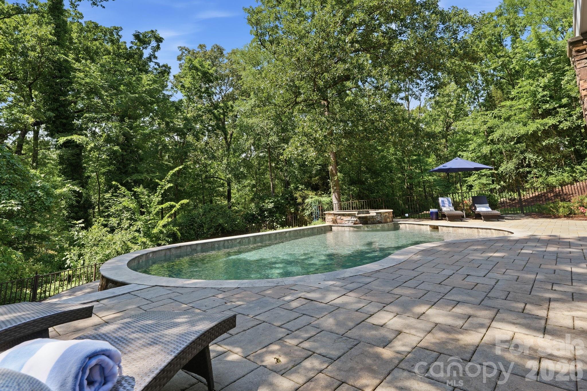 235 Grey Road offers a rare opportunity to own one of the few true 5-bedroom homes in downtown Davidson. Situated on an exceptional and private .9-acre lot backing directly to Davidson College, this custom-built residence combines timeless craftsmanship, expansive living spaces, and an unbeatable walkable location just moments from downtown Davidson’s shops, restaurants, and parks.

Originally constructed by a renowned local builder as his personal residence, the home showcases thoughtful design and quality throughout. Featuring 5 bedrooms, 4.5 baths, and a finished basement with full kitchen and recreation area, the property offers flexible living spaces ideal for both everyday living and entertaining.

The backyard is a true retreat, with a private setting overlooking mature landscaping, a salt-water pool, fire pit, and in-ground trampoline—creating a rare outdoor experience in the heart of Davidson. With nearly an acre of land, exceptional privacy, and a highly sought-after location, 235 Grey Road represents a unique opportunity to own one of downtown Davidson’s premier family homes.