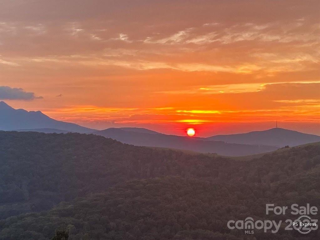BRING ALL OFFERS !! Wow! What a remarkable view! Amazing long range views of Grandfather Mountain and many more mountain ranges. Elevation of over 4400 FT. Inside you will appreciate the big open view through the massive windows from the Living Room, Enjoy the kitchen with granite counters. Vaulted ceilings, stone fireplace, and wood floors make this a mountain paradise. The beautiful wrap around deck lets you enjoy the outdoors as well while you take in the breathtaking views and morning sunrises. Main level offers Primary Bedroom and Bathroom with Jacuzzi Tub. Primary also has a 6x12 walk in closet. The laundry room is on main level as well. The lower level offers 2 more Bedrooms and a Bath. There is a play room/Den on that level too. Attached 2 car garage, oversized detached 24 x 48 work shop/RV storage and detached carport offer more than enough covered or enclosed parking. Outside of home has new stain on Exterior Logs and fenced back yard. $1500 appliance allowance to new buyer.