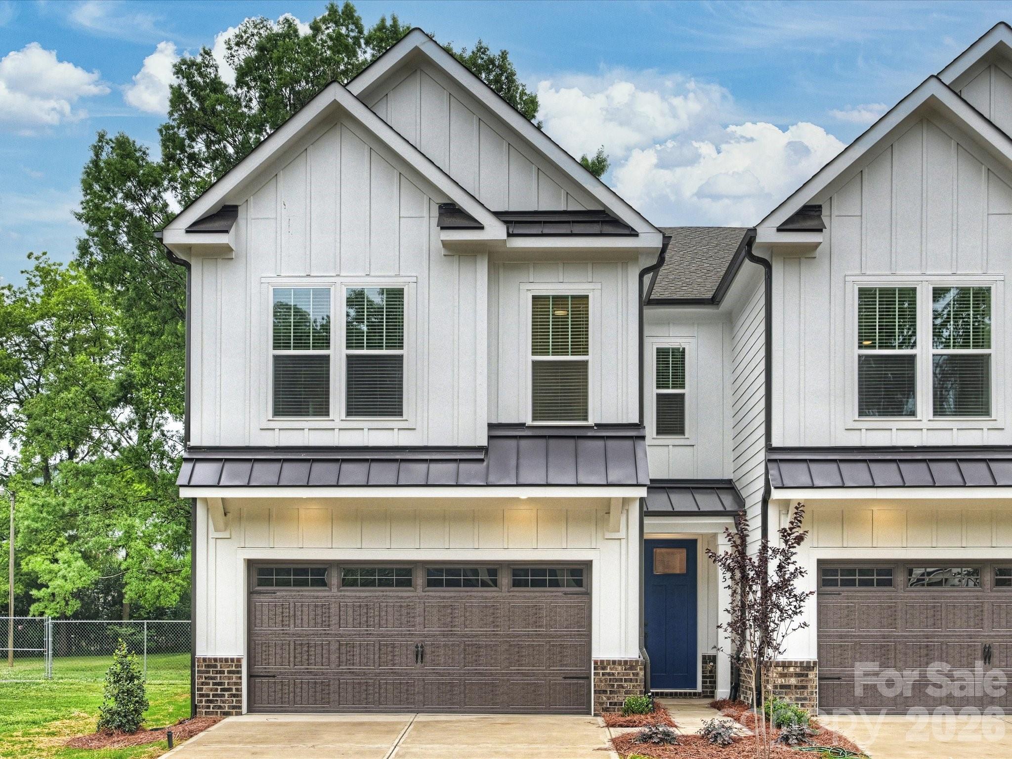 One of two exceptionally built new-construction duets on one of the premier streets in NoDa. Step inside through the covered front porch and immediately notice the soaring ceilings, upgraded LED lighting, and durable wood laminate flooring throughout the main level.

The chef’s kitchen spares no expense, featuring a large island with quartz waterfall countertops and a built-in microwave drawer, upgraded backsplash, gas range with a stainless steel hood vent, and stainless steel refrigerator.

The spacious living room flows effortlessly from the kitchen into the dining area, creating an ideal layout for entertaining while maximizing the home’s abundant natural light.

Upstairs, the bonus/flex space continues the sustainable wood laminate flooring and offers the perfect setup for a second living area, playroom, or home office.

The incredible primary suite features an expansive walk-in closet with custom built-ins. The spa-like primary bath includes a dual vanity, quartz countertops, upgraded lighting package, and a walk-in shower with designer tile.
Two generously sized secondary bedrooms include upgraded lighting and spacious closets with upgraded closet systems.

This is far from your standard laundry room, complete with fun mosaic tile, upper and lower cabinetry for additional storage, and a convenient folding space.

No pesky tandem parking here — the two-car garage easily accommodates side-by-side parking and includes a built-in drop zone plus a custom technology nook ideal for working from home.

Outside, enjoy a rare private backyard complete with a wooden privacy fence and patio.

Located just blocks from neighborhood favorites like Haberdish, The Local Loaf, Neighborhood Theatre, and The Artisan's Palate, this home offers the perfect blend of luxury and walkable urban living in the heart of NoDa.