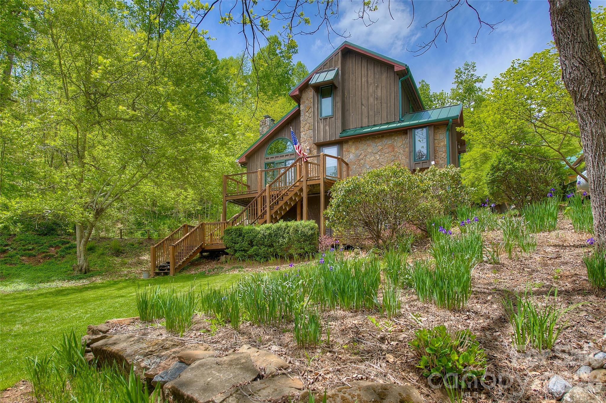 Two Homes On an Un-Subdivided 4.22 Acres— The Perfect Family Homestead— In Beautiful Little Switzerland! NO HOA!  NO RESTRICTIONS! Think Vacation Rental Possibilities!— Think Sustainability!— Think Legacy! An excellent 1031 exchange possibility. Both exceptionally tasteful homes feature individual 10K household Generac propane fueled generators [installed in 2025 (with a 5 year warranty in place)] for times when the grid may go down. A new shared well for the two homes (new in 2024), providing 10 gal. per min. of good mountain water, w/ complete filtration system and backwash, ensuring high quality.  Starlink is the choice for both homes (professionally installed) in high speed connectivity (average Mbps over 300), & high speed fiber is available via local provider. The property is curated to blend indoor & outdoor living to a near perfect match for the beauty & climate in this highly desired community. Black walnut & chestnut trees overlook the curated family campus w/ 7 fenced raised bed vegetable gardens, mature apple, pear & peach trees, along w/ an orchard of grapes & raspberries. The center point is a custom “Pub Shed” built w/ hemlock & stunning cedar trim & countertops, w/ water/electric, & platformed on beautiful flagstone pavers w/ a stone wall encircling the stone fire-pit. The surrounding soil is planted w/ 1000 mature lavender plants serving not only as aesthetic value, but also deterring pernicious beasts & insects. At the shed’s rear is a custom state of the art greenhouse, also w/ water & electric to power the misting system which in conjunction w/ the polycarbonate roof keeps plants warm & hydrated for year round production. There is room for another home to be constructed on a section of the property boasting dramatic 180 views of the Mount Mitchell & Black Mountains Range, as well as the mountains surrounding Little Switzerland, all while overlooking the beautiful lake on an adjoining property.
The main house, completed in 2004, is a rustic mountain lodge style home featuring 3BD/2BA, generous decks, standing-seam metal roof (4 years old), rich wood & stone accents. Indoor comfort- delivered via the modern Mitsubishi ductless multi-zone heat/ac system, as well as two gas log units. Lifestyle here is enhanced w/ the valued ceilings, wood-paneled walls, the open yet cozy layout, and a kitchen showcasing granite counters, stainless appliances w/ a gas range, & under-cabinet lighting. A tankless hot water on demand system is powered via propane, & a new Seville Classics 8-piece basement storage set is included in the sale.
Complementing the main residence is the guest house, a 2023 modern contemporary build that feels bright, open & fresh. Clean lines, quartz countertops, stainless appliances, easy-close cabinetry, & an open floor plan define this homes aesthetic. The spacious one-bedroom, one-bath layout includes a convenient main-level laundry, office nook, & like the main house, a Mitsubishi ductless multi-zone heat/ac system. Together, the two homes create an ideal multigenerational or income-producing compound— truly scarce in this sought-after mountain enclave. Included with this property are two UTVs, a 2022 Polaris Ranger Crew, and an 2008 Yamaha Rhino with a snow plow. Every time you go to the PO or grocery shopping, you are in fact taking a scenic drive that the majority of people in this world would have to save a lifetime just to come and visit! ?5 min. to Little Switzerland, 15 min. to Spruce Pine & The Grassy Creek Golf and Country Club, & the Blue Ridge Regional Hospital; 5 min. to the Blue Ridge Parkway; 20 min. to the famous Penland School of Crafts; 30 min. to Burnsville, 40 min. to fine dining, ski resorts and other entertainment at Banner Elk, Beach Mountain, & Sugar Mountain, as well as Mountain Glen Golf Course in Newland; 30 min. to Lake James, Marion, & I-40; 60 min. to Asheville, NC; 70 min. to Johnson City, TN, & the Tri-Cities Airport, 2hrs. from Charlotte.
