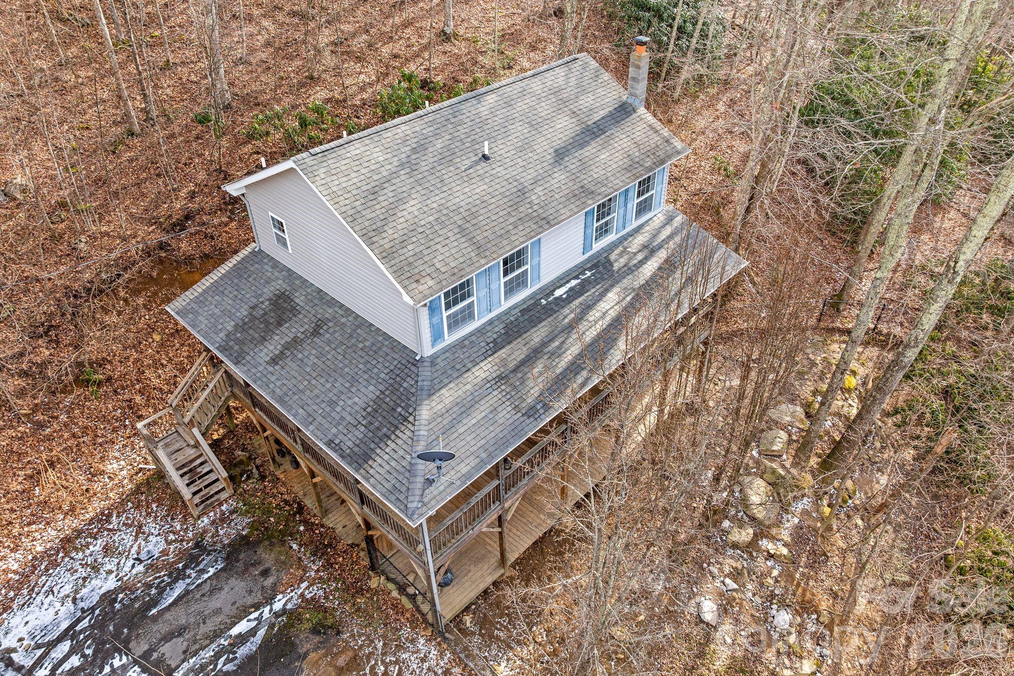 Retreat to a lush wooded hideaway–Located at 842 Grouse Rd in Clyde, North Carolina, this 3-bedroom, 2.5-bathroom home on a 0.91-acre wooded lot. It sits at an elevation over 3,700 feet, providing privacy, a quiet country setting, and mountain views. The exterior includes a large wraparound covered porch and deck for outdoor relaxation, along with a fenced in front yard. Inside, the main level has a spacious a dining room and living room with mountain views, a half bath, and laundry area. The upper level contains all three bedrooms, including walk-in closets, and two full bathrooms. The finished basement is versatile space, such as a den, home gym, craft, or game room. 

Schedule a your showing today.