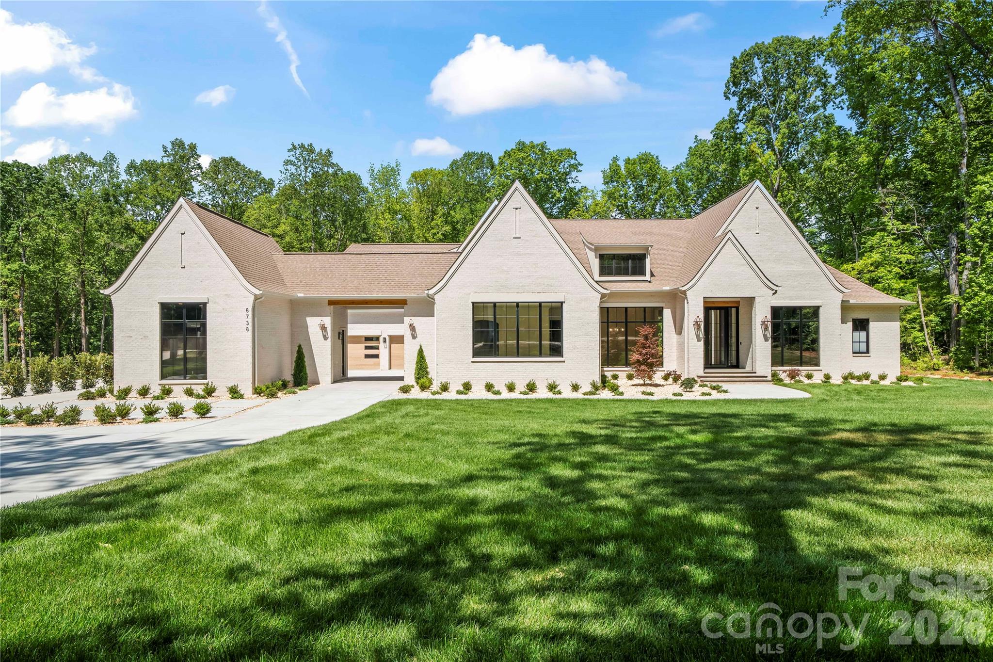 Breathtaking, designer-built, single-level home located on over an acre in the thriving Indian Land. This modern, all-brick home offers understated elegance and an open floor plan, perfect for both entertaining and family living.
The open-concept design is filled with natural light and features high ceilings and a gourmet chef’s kitchen equipped with top-of-the-line built-in SubZero refrigerator and a Wolf range and quartz/quartzite countertops. 
A second full kitchen provides a separate, private cooking space with built- in appliances -ideal for keeping the main kitchen pristine-while offering additional storage and counter space. It also provides access to a built-in outdoor kitchen and a sitting area with a built-in gas fireplace, creating a warm and inviting atmosphere.The hardwood floor flows throughout the entire house, adding warmth and character to the space. The spacious layout includes a large primary suite with an oversized walk-in closet and a luxurious en-suite bath featuring a large walk-in shower and a freestanding tub. A dedicated office offers the perfect space for remote work, while three additional bedrooms -each with private bathrooms and walk in closets-provide flexibility for family, guests or additional workspace. 
The oversize bonus room upstairs includes a sitting area, play space and a large wet bar, making it ideal  for entertainment. An additional 520 - square-foot carpeted space ready to be wired for a projector, to be transformed into a home theatre or simply used for a playroom. The heated one-car garage features LVP flooring and a half bath and can be used as an office, gym, or a showcase space for a sports vehicle, visible through the glass garage door. 
The encapsulated crawl space prevents water intrusion, reducing the risk of mold and structural damage while improving energy efficiency. Two gas tankless water heater with recirculating pumps provide continuous hot water while conserving energy.  A gas generator ensures uninterrupted power, offering peace of mind, and comfort during outrages. This gorgeous house is located just minutes from Ballantyne, and I-485, where the residents enjoy convenient access to shopping, dining, entertainment, and everyday essentials including Costco Wholesale and MUSC Health Lancaster Medical Center. Don't miss this rare opportunity to own a new, move-in-ready home with lots of privacy and architectural charm and modern amenities! Listing agent owner/broker.