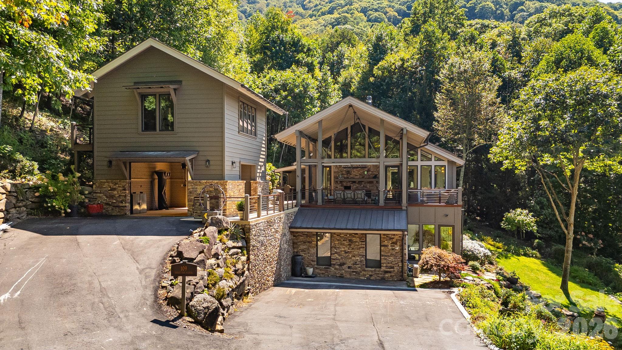 Perched at an awe-inspiring 4,300 feet within the prestigious Balsam Mountain Preserve, this exceptional estate captures the essence of elevated mountain living, where crisp “sweater weather” and cool breezes provide amazing summer days. Gorgeous views of layered blue ridgelines provide a stunning natural backdrop that shifts beautifully with the light.

As a truly move-in ready retreat, the home blends timeless mountain architecture with refined, modern upgrades. The inspired use of wood, stone, glass, and steel creates a striking architectural statement that harmonizes with its natural surroundings. Dramatic floor-to-ceiling glass walls flood the interior with natural light and perfectly frame the vistas from nearly every room. An open-concept great room anchored by a grand fireplace create a warm yet sophisticated atmosphere. The chef’s kitchen is a standout, featuring striking quartzite countertops paired with exquisite Italian Snaidero custom cabinetry and premium appliances.
Offering 4 bedrooms and 4.5 baths, this home has been thoughtfully updated with high-end finishes and beautifully remodeled bathrooms with onyx countertops. The lavish primary suite is a sanctuary of comfort, featuring a spa-like soaking tub, private patio, and radiant heated floors. Flexible spaces abound, including a private suite above the garage—ideal for guests, a studio, or office—and a lower-level art studio that can easily convert back to a garage. Heated floors continue through the second dining room and lower-level corridor ensuring year-round indulgence.

Indoor and outdoor living merge effortlessly with expansive outdoor living spaces.  Outdoors you will find a grand deck covered with its own fireplace, cascading terraces with a lighted water feature, and a private fire pit—each perfect for luxurious entertaining or serene evenings under the stars and unforgettable sunsets.  The landscaping has been exquisitely curated to fit the property perfectly.

As part of this private, gated community, residents enjoy an unparalleled lifestyle with access to incredible amenities, including a championship Arnold Palmer golf course, a state-of-the-art wellness center, and multiple dining venues offering everything from casual fare to elevated culinary experiences. Forty miles of scenic hiking trails and preserved natural landscapes further enhance the sense of serenity and connection to the outdoors.
This is a rare opportunity to own a turnkey luxury retreat in one of the region’s most sought-after high-elevation communities—where every detail is complete and every day feels like the perfect mountain escape.