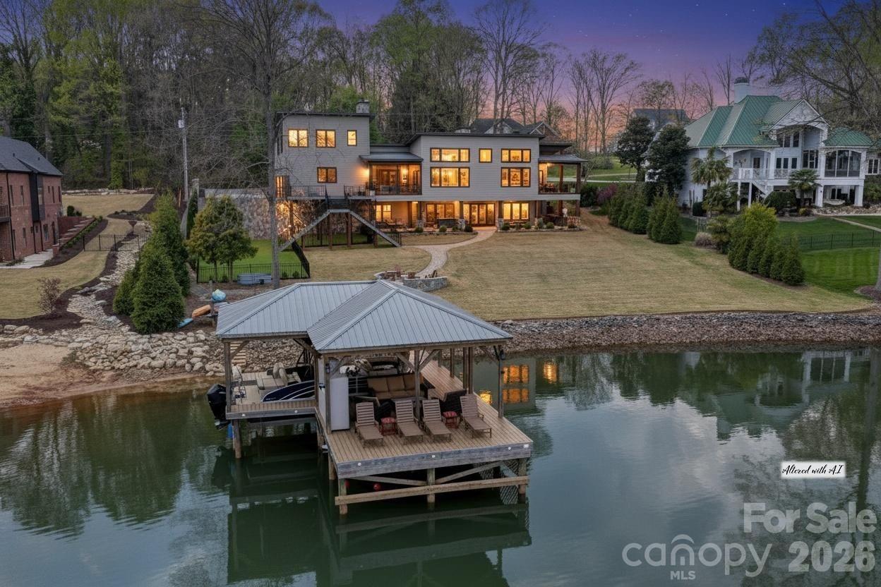 Experience luxury lake living in this custom Modern Craftsman home built in 2021, perfectly situated on a large lot in Mooresville with no HOA. Thoughtfully designed with exceptional craftsmanship and one-of-a-kind details, this home offers a truly elevated lifestyle with amazing lake views from almost every room in the home.. At the heart of the home is a grand chef’s kitchen featuring custom cabinetry and stunning black walnut accents milled directly from a tree on the property, showcased in the trim, floating shelves, range hood, and island. The adjoining family room continues the theme with custom walnut built-ins, creating a warm yet refined gathering space. Designed for flexibility and comfort, the home offers side by side, dual primary suites, each complete with a private bathroom, walk-in closet, and dedicated office area—ideal for multi-generational living or ultimate guest accommodations. The main primary suite also features a private covered porch for a peaceful retreat. Upstairs, you’ll find a large bonus room with a connected office suite (currently used as guest quarters), offering incredible flexibility for guests or additional living space, all complemented by amazing lake views. This home is an entertainer’s dream, highlighted by expansive sliding doors and a custom pass-through kitchen window that seamlessly connect indoor and outdoor living to a large screened porch with fireplace and an oversized deck. The walk-out basement is equally impressive, featuring two additional bedrooms with custom built-in bunk beds and private baths, a spacious living area, exercise room, and a must see, custom wine cellar. Step outside to enjoy the beautifully designed exterior, including a huge covered patio, custom fire-pit, and a fenced in, turf dog run. Just off the lower patio, you’ll find a large storage area perfect for all your lake gear and outdoor essentials. Waterfront living is complete with a newly built 1,000 sq ft covered dock and 7,000 lb boat lift, making this property ideal for enjoying Lake Norman to the fullest. With abundant storage, custom built-ins throughout, and unmatched attention to detail, this home is a rare opportunity in one of Mooresville’s most desirable locations.  DEEP Water off Dock! Water Depth is 25'+ at full Pond!