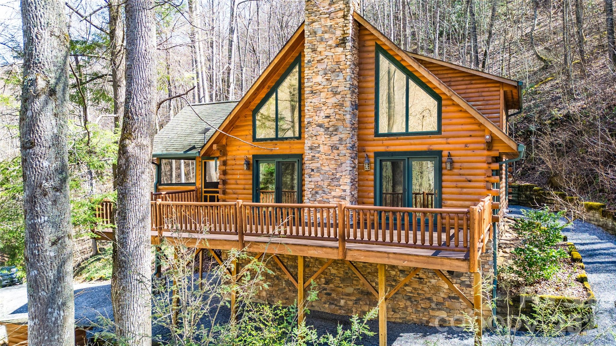 Beautiful 3-bedroom, 2-bath D-log home nestled on nearly 4 acres along picturesque Dicks Creek, offering the perfect blend of mountain privacy and convenience. Situated at approximately 3,000 feet in elevation, this home provides comfortable four-season living and scenic surroundings with 450 feet of creekfront. Inside, the home features updated appliances, an on-demand propane hot water heater, and the peace of mind of a whole-home on-demand generator. The layout offers convenient main-level living, with the primary bedroom located on the first floor, while two well-appointed guest bedrooms are situated upstairs. Step outside to enjoy the spacious deck and screened-in porch, where you can relax to the soothing sounds of Dicks Creek and take in the natural beauty of the property. Ideally located just 12 minutes from the charming village of Dillsboro, and only 20 minutes from Sylva, Bryson City, and the Great Smoky Mountains National Park, this property provides convenient access to dining, shopping, outdoor recreation, and park adventures. Great vacation getaway, seasonal rental, or full-time mountain residence. This beautiful creekside retreat offers exceptional opportunity.