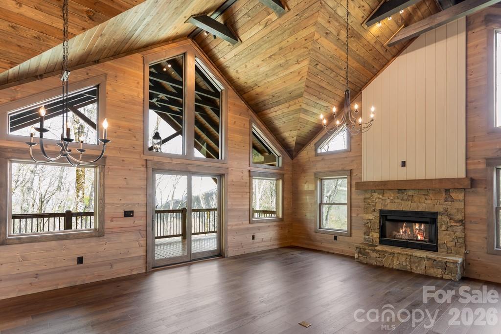 Looking for a completed new construction move in ready 3-bed mountain home in Maggie Valley with high-end finishes and long-range views? This custom log-style retreat in Smoky Mountain Retreat at Eagles Nest blends luxury, durability, and natural beauty in a private gated setting.

Located on 1.4 wooded acres at over 4,400 feet in Smoky Mountain Retreat at Eagles Nest, 102 Iga Trail offers 3 bedrooms, 3.5 bathrooms, and 2,592 sq ft of professionally designed living space. Built with 12" steel-reinforced poured concrete walls, hand-hewn log siding, and hurricane-rated windows, this home is as solid as it is stunning.

Inside, you'll find tongue-and-groove vaulted ceilings with exposed beams, hardwood floors, and a 42” wood-burning fireplace with gas starter. The main-level primary suite includes custom wood closet systems and a spa-like bath. The kitchen is equipped with GE and KitchenAid appliances, a gas range, island drawer microwave, and vented range hood.

Downstairs, a finished walk-out level features guest suites, a rec room, and access to the lower 12' x 48' covered deck. Both levels have decks offering over 1,100 sq ft of outdoor living.

Outdoor living is where this home truly shines. An expansive deck provides the perfect place to unwind, entertain, and take in fresh mountain air, surrounded by trees and layered mountain scenery. Whether sipping morning coffee, hosting friends, or enjoying peaceful evenings, this outdoor space delivers the mountain lifestyle so many buyers are seeking.

Other highlights include a dual-zone Carrier HVAC, tankless water heater, encapsulated crawl space, and a low-slope driveway to a 22' x 23' garage.

Minutes from downtown Maggie Valley, Cataloochee Ski Area, and the Blue Ridge Parkway.

Key Features:
• 3 beds, 3.5 baths, 2,592 sq ft
• 1.4-acre wooded lot with privacy and mountain views
• Hurricane-rated windows and doors
• Vaulted tongue-and-groove ceilings, hardwood floors
• Custom kitchen with gas range, French door fridge, Taj Mahl Quartzite counter tops in Primary bathroom
• 42” wood-burning fireplace with gas starter w/ owned buried propane tank ($4,500 Value)
• Fully encapsulated crawl space with dehumidifier
• Dual-zone Carrier HVAC, tankless gas water heater
• 12' x 48' decks on both levels with exposed beams
• Oversized 2-car garage and paved driveway
• Gated community with paved access

Located in sought-after Maggie Valley, you’re just moments from dining, shopping, outdoor recreation, and nearby Waynesville, while still feeling worlds away from the rush of everyday life. Thoughtfully designed and move-in ready, this property offers a rare opportunity to own a beautiful mountain escape with the comfort and livability you need to truly enjoy it.

Come experience the mountain lifestyle—comfort, privacy, nature, and ease, all in one inviting retreat.