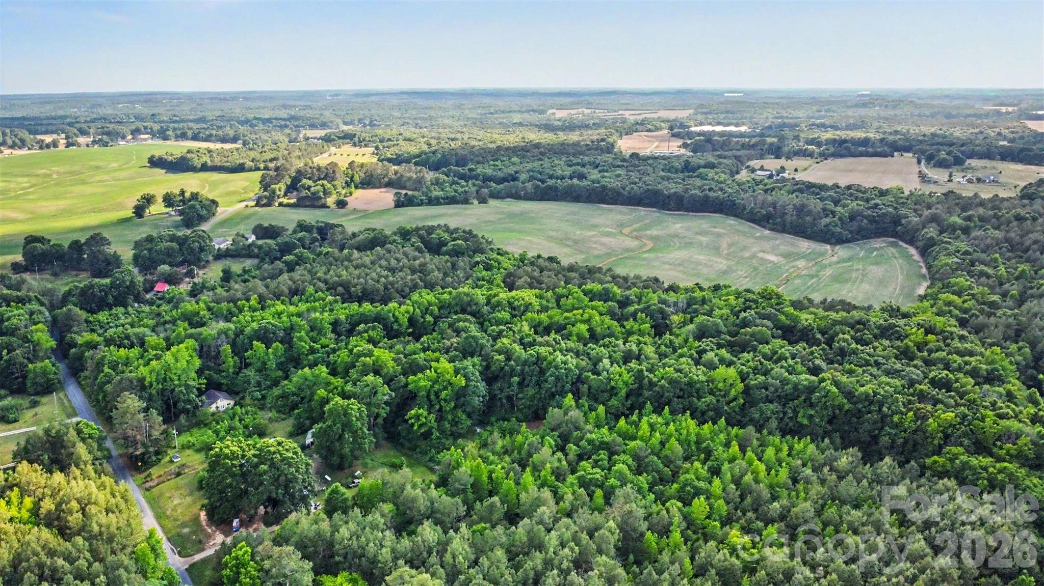 Discover the possibilities on this beautiful 13.7-acre wooded property offering privacy, natural beauty, and versatility for a variety of future uses. Surrounded by open farmland and scenic countryside views, this expansive tract provides an ideal setting for those seeking a rural lifestyle, a private homesite, agricultural opportunities, or a long-term land investment.

The property features mature timber, abundant wildlife habitat, and a peaceful natural setting that creates an attractive backdrop for a custom-built home, family estate, hobby farm, small agricultural operation, or recreational retreat. An established access easement provides entry to the property while preserving its secluded character. Buyers are encouraged to verify intended uses, building requirements, utility availability, and access details with local authorities.

Home structure on the property is not safe to access and should not be entered.  The status of the 300 ft well and septic system is unknown.