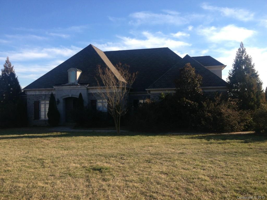 Large home with lots of potential just over the Cabarrus County line.  Water view.  Large great room with built-ins and beamed ceiling, 2 master closets (1 with hidden safe room), dramatic ceiling in master bedroom, large kitchen with custom cabinets, huge upstairs bonus with private bath.  3 bedrooms down and bedroom/bonus with private bath up.  Outdoor living area with fireplace overlooks water.  Great investment!