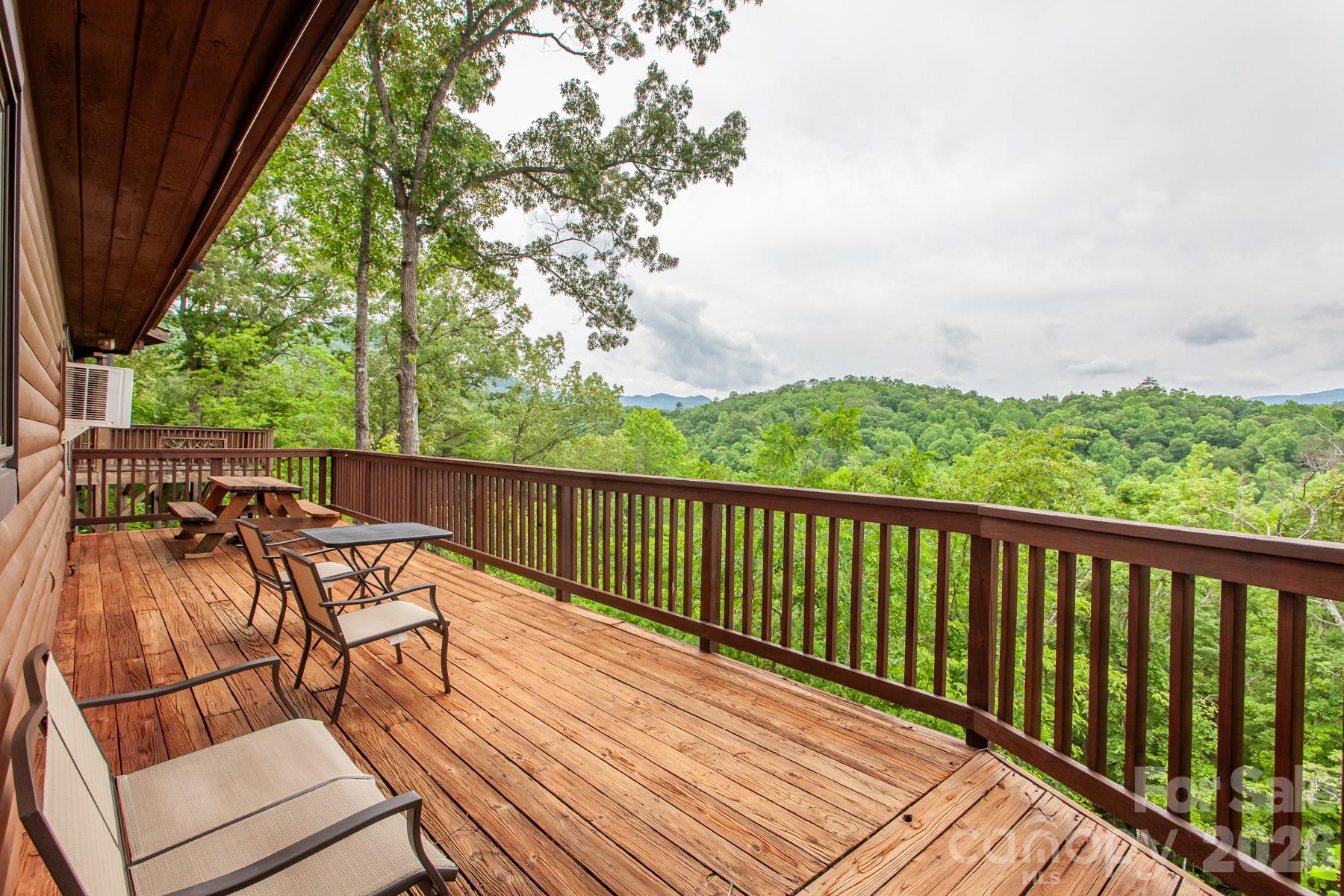 Charming 2-bedroom, 1-bath fully furnished cabin with breathtaking long-range views of the Great Smoky and Nantahala Mountains! This inviting retreat features warm tongue-and-groove walls and ceilings, hardwood floors, and a spacious deck perfect for enjoying the scenery. Inside, the open-concept layout connects the kitchen, dining, and living areas, creating an ideal space to relax or entertain. The split-bedroom design offers privacy, with a full bath conveniently located between the bedrooms. Dry storage beneath the cabin provides easy space for kayaks and outdoor gear after a day of adventure. Located just minutes from the Nantahala River, Lake Fontana, Almond Boat Dock, Tsali Recreation Area, and downtown Bryson City, this property offers easy access to top outdoor attractions. Community amenities include a restaurant and bar, pool, game room, fitness center, and indoor and outdoor gathering spaces, with optional horseback riding available. Being offered fully furnished, just bring your toothbrush and start enjoying the cabin the Smokys you've always dreamt of!