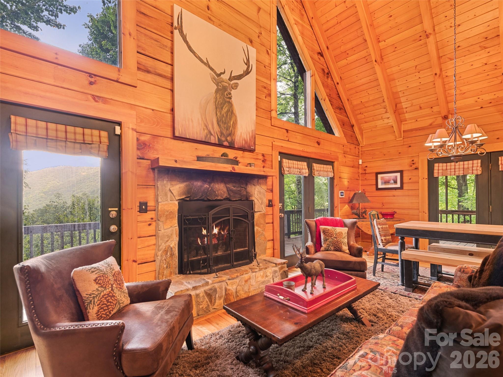 Short term rentals allowed!!  Being sold fully furnished!! Escape to your own Smoky Mountain retreat at 297 Hidden Cove Road. Tucked among the trees in the desirable Smoky Falls community, this authentic log cabin offers the perfect blend of mountain character, long-range views, privacy, and convenience. Whether you're searching for a full-time residence, private second home, family getaway, or short-term rental opportunity, this property captures the mountain lifestyle buyers come to Maggie Valley to find. From the moment you arrive, you'll appreciate the peaceful setting and timeless appeal of this beautifully maintained log home. Surrounded by nature and positioned to enjoy long-range mountain and valley views, the property feels tucked away from the world while remaining just minutes from the attractions and recreation that make Maggie Valley one of Western North Carolina's most popular mountain destinations. Inside, soaring cathedral ceilings, exposed beams, warm wood finishes, and abundant natural light create a dramatic yet welcoming mountain-lodge atmosphere. The spacious great room is anchored by a beautiful wood-burning stone fireplace, creating the perfect gathering space after a day spent hiking, skiing, exploring, or simply enjoying the mountains. Expansive windows bring the outdoors in while enhancing the open and airy feel throughout the home. The open-concept layout allows the kitchen, dining area, and living room to flow seamlessly together, making entertaining family and friends effortless. The kitchen features abundant cabinetry, generous counter space, a gas range, kitchen island seating, and easy access to the dining area. Whether hosting guests or preparing a quiet dinner at home, the layout is designed for both comfort and functionality. The main level offers two bedrooms and a full bathroom, providing convenient everyday living. Upstairs, the loft overlooks the great room below and offers additional versatile living space along with a second full bathroom. Outdoor living is where this property truly shines. Multiple outdoor spaces provide opportunities to enjoy every season in the Smokies. Start your mornings with coffee while taking in mountain views, spend afternoons relaxing on the covered porch, gather with friends on the deck, or unwind on the screened porch surrounded by the sights and sounds of nature. One of the home's most memorable features is the screened porch complete with a charming bed swing, creating the perfect mountain retreat experience. Pride of ownership is evident throughout, offering future owners a property that feels cared for and well-loved while still providing flexibility for a variety of uses. Located near downtown Maggie Valley, Waynesville, Cataloochee Ski Area, the Blue Ridge Parkway, Cherokee, hiking trails, dining, shopping, and year-round outdoor recreation, this home offers easy access to everything that makes Western North Carolina special. Skiing, hiking, fishing, scenic drives, waterfalls, festivals, and mountain adventures are all within reach. If you've been searching for an authentic Maggie Valley log cabin with long-range views, soaring ceilings, a stone fireplace, inviting outdoor living spaces, versatile loft living space, and the peaceful mountain atmosphere buyers dream about, 297 Hidden Cove Road is ready to welcome you home.