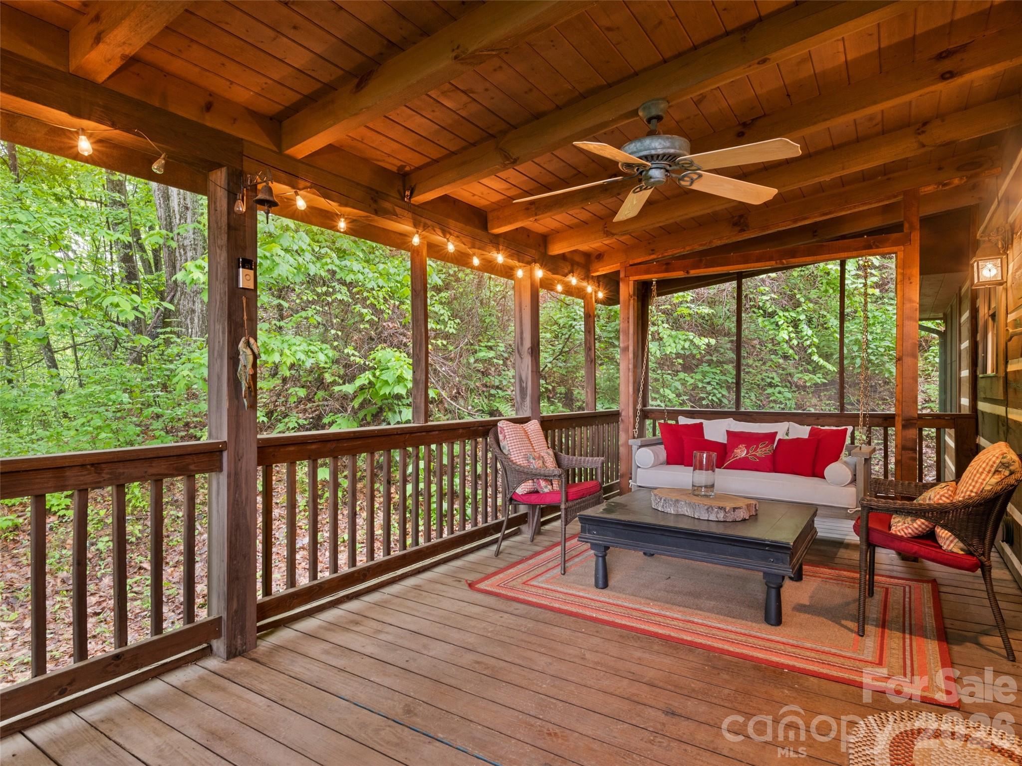 Escape to your own Smoky Mountain retreat at 297 Hidden Cove Road. Tucked among the trees in the desirable Smoky Falls community, this authentic log cabin offers the perfect blend of mountain character, long-range views, privacy, and convenience. Whether you're searching for a full-time residence, private second home, family getaway, or short-term rental opportunity, this property captures the mountain lifestyle buyers come to Maggie Valley to find. From the moment you arrive, you'll appreciate the peaceful setting and timeless appeal of this beautifully maintained log home. Surrounded by nature and positioned to enjoy long-range mountain and valley views, the property feels tucked away from the world while remaining just minutes from the attractions and recreation that make Maggie Valley one of Western North Carolina's most popular mountain destinations. Inside, soaring cathedral ceilings, exposed beams, warm wood finishes, and abundant natural light create a dramatic yet welcoming mountain-lodge atmosphere. The spacious great room is anchored by a beautiful wood-burning stone fireplace, creating the perfect gathering space after a day spent hiking, skiing, exploring, or simply enjoying the mountains. Expansive windows bring the outdoors in while enhancing the open and airy feel throughout the home. The open-concept layout allows the kitchen, dining area, and living room to flow seamlessly together, making entertaining family and friends effortless. The kitchen features abundant cabinetry, generous counter space, a gas range, kitchen island seating, and easy access to the dining area. Whether hosting guests or preparing a quiet dinner at home, the layout is designed for both comfort and functionality. The main level offers two bedrooms and a full bathroom, providing convenient everyday living. Upstairs, the loft overlooks the great room below and offers additional versatile living space along with a second full bathroom. Outdoor living is where this property truly shines. Multiple outdoor spaces provide opportunities to enjoy every season in the Smokies. Start your mornings with coffee while taking in mountain views, spend afternoons relaxing on the covered porch, gather with friends on the deck, or unwind on the screened porch surrounded by the sights and sounds of nature. One of the home's most memorable features is the screened porch complete with a charming bed swing, creating the perfect mountain retreat experience. Pride of ownership is evident throughout, offering future owners a property that feels cared for and well-loved while still providing flexibility for a variety of uses. Located near downtown Maggie Valley, Waynesville, Cataloochee Ski Area, the Blue Ridge Parkway, Cherokee, hiking trails, dining, shopping, and year-round outdoor recreation, this home offers easy access to everything that makes Western North Carolina special. Skiing, hiking, fishing, scenic drives, waterfalls, festivals, and mountain adventures are all within reach. If you've been searching for an authentic Maggie Valley log cabin with long-range views, soaring ceilings, a stone fireplace, inviting outdoor living spaces, versatile loft living space, and the peaceful mountain atmosphere buyers dream about, 297 Hidden Cove Road is ready to welcome you home.