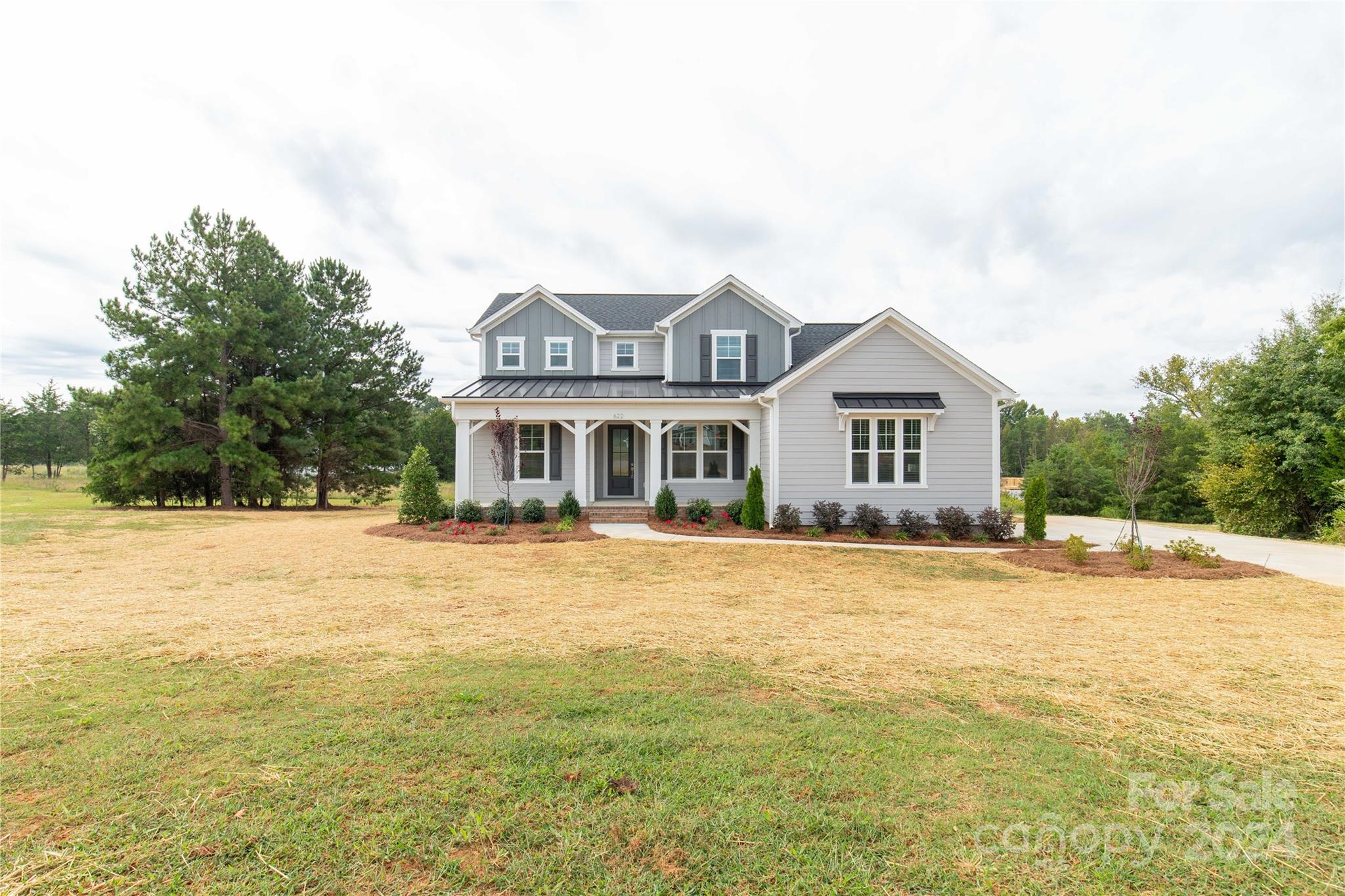 This new construction is located on a 1-acre lot on a cul-de-sac street. The 1st floor features a Primary suite with a private door to a screened back porch, overlooking a spacious backyard. The primary bath includes a frameless glass shower, a large walk-in closet, and convenient bath-to-laundry access. There is a guest room with a full bath on the 1st floor. The stunning kitchen comes with upgraded white cabinets, a large Maple Rye stained island with sparkling white quartz countertops, and a spacious walk-in pantry. The kitchen also includes a butler's pantry and opens to a large great room, which features a gas fireplace, coffered ceiling, and access to the rear porch. There's even a formal dining room that can also function as an office. Upstairs, you'll find a sprawling 26'x16' loft and 2 additional bedrooms connected by a shared bath with private vanities. This home is located in the Clover School District. Builder offering up to 10k in concessions with a full-price offer.