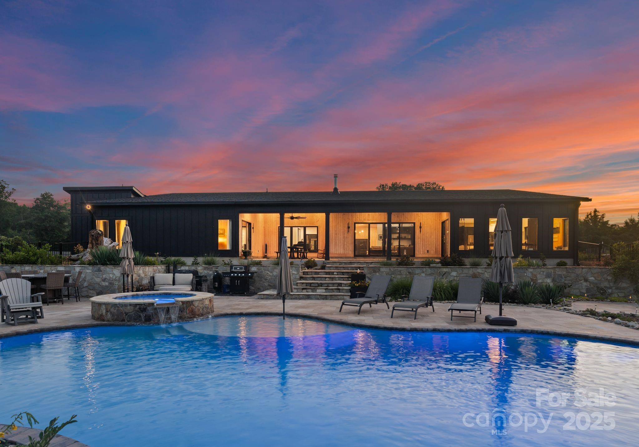 Discover unparalleled privacy and luxury in this stunning custom-built modern estate, completed in 2023 set on 34.1 acres. This luxury property offers the perfect blend of high-end living and functional farm life. The main home features an open-concept layout with vaulted ceilings, interior courtyard, Gyrofocus suspended fireplace, and polished concrete floors throughout. The gourmet kitchen is a chef's dream with dual islands, 10-burner range, pantry, and premium appliances. Spacious primary suite, 3 guest bedrooms, a bonus/flex room, and oversized 3-car garage. Outdoor living includes a 23,000-gallon saltwater pool, travertine pool deck, and a covered outdoor dining area. A separate 2BR guest cottage with full kitchen, hot tub, and private patio offers guest space or rental potential. Property includes multiple barns, fenced pastures, fruit trees, private trails, spring water, 2 wells, and whole-house water filtration. No HOA. Endless possibilities—farm, retreat, or private estate!