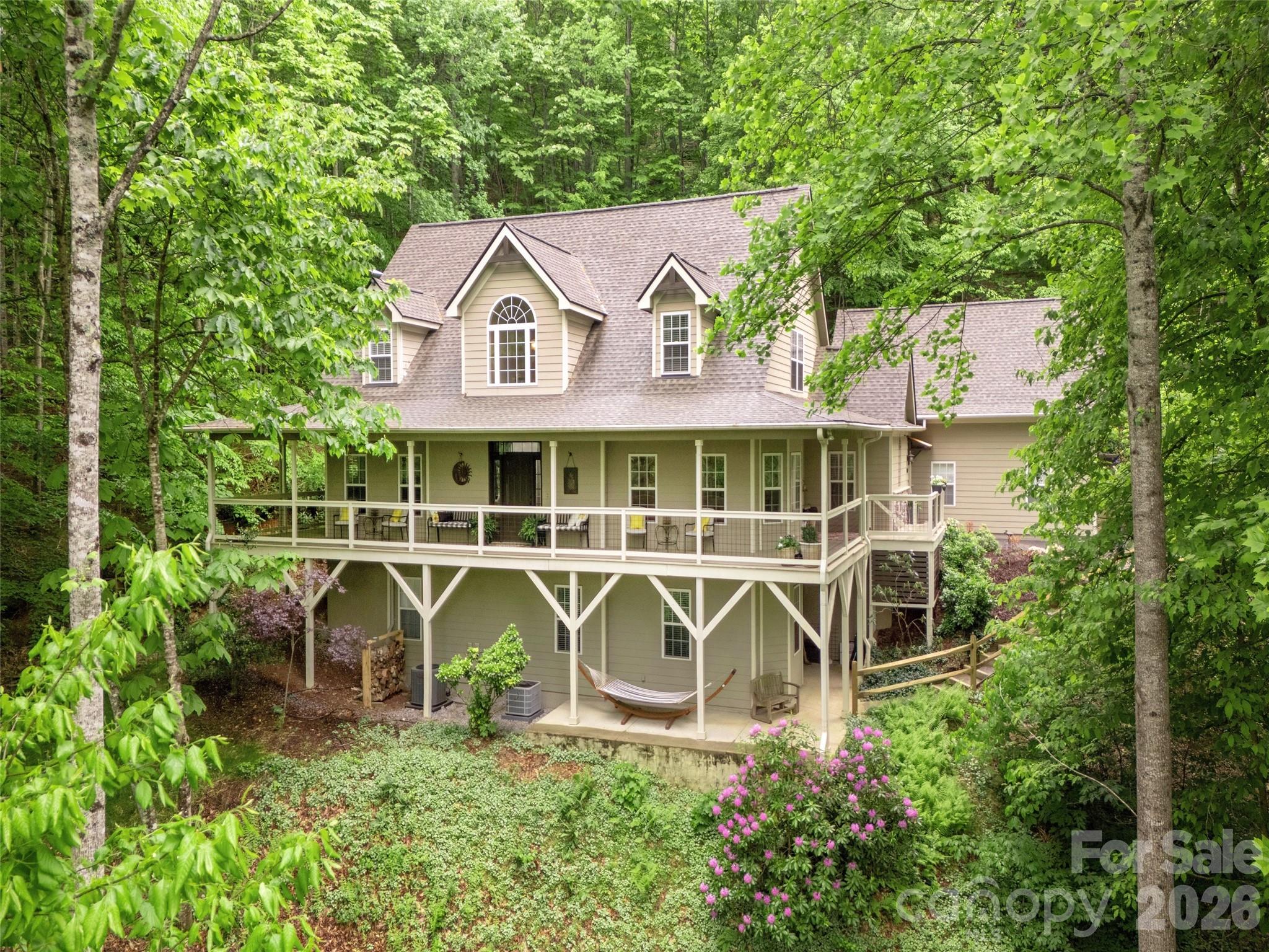 Imagine your mornings with coffee on the expansive wraparound porch, where year-round mountain views and
the gentle sound of a babbling brook set the tone for a peaceful day. Set within a gated community, this
beautifully updated home features an impressive two-story great room with gleaming wood floors and a
dramatic stone fireplace with a hand hewn sycamore mantle—warm and welcoming in every season. The spacious primary suite is a private retreat with a remodeled, spa-like bath that includes dual vanities, a soaking
tub and tiled step-in shower. The kitchen balances style and function with a gas cooktop, updated
backsplash and an open layout that flows into the great room and breakfast area. Flexible living spaces
let you tailor the home to your needs: a dedicated dining room or office, a large bonus room and a cozy
screened porch offer options for work, relaxation, and hosting. Upstairs two generously sized bedrooms
share a full bath. For added peace of mind, the roof, both HVAC systems and the water heater are less than
five years old, and high-speed fiber has recently been run throughout the neighborhood.An unfinished basement provides excellent storage and workshop space, with the option to expand by more than 800 additional square feet. Community amenities include a clubhouse, outdoor pool, playground, tennis/pickleball courts, and scenic walking trails that connect to the national forest!