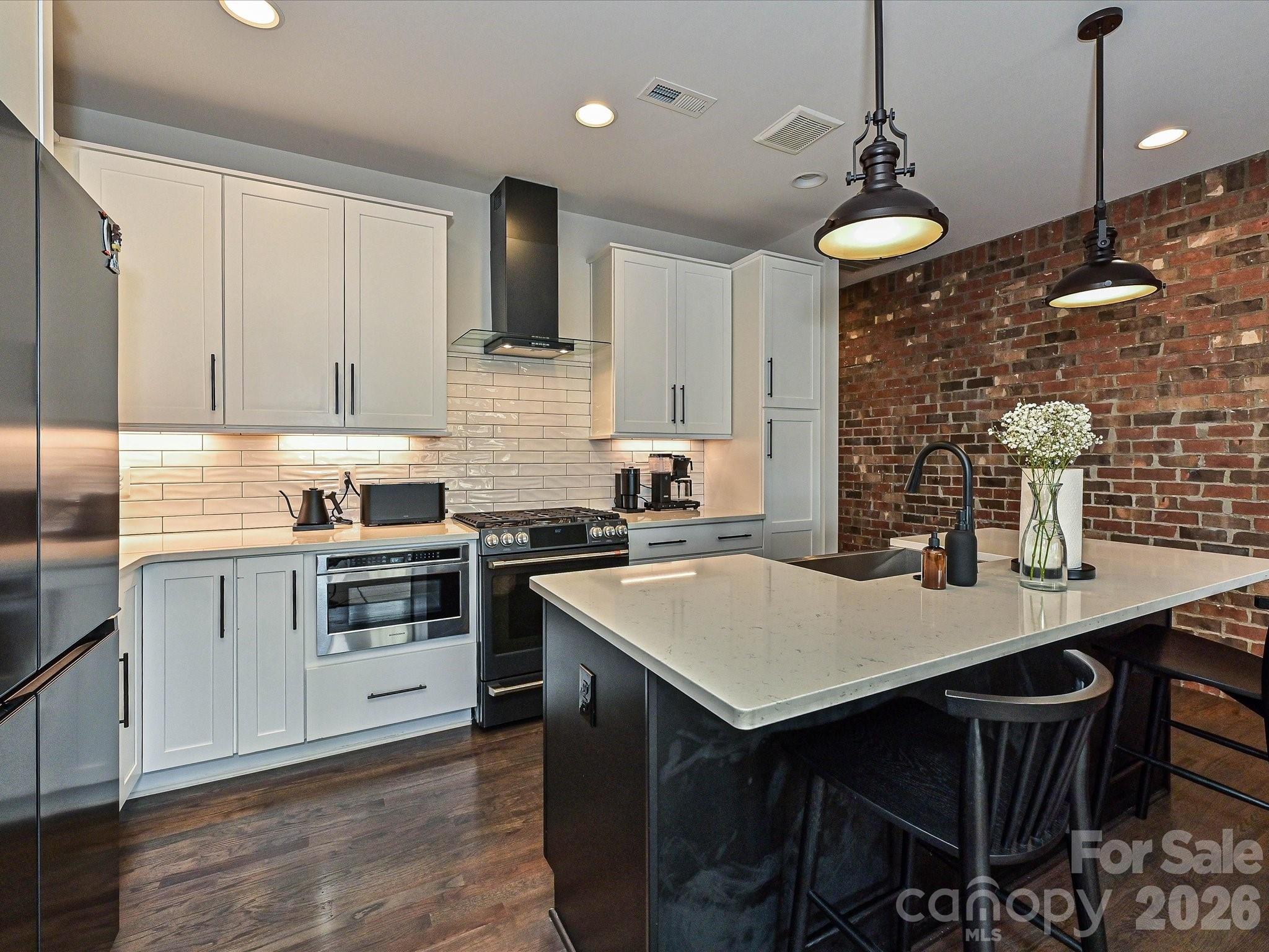 Welcome to Highland Park — a brick brownstone townhome in the heart of NoDa. Recently built, this 4-bedroom, 4.5-bath home delivers a sleek, modern interior that feels like it belongs in a design magazine. The main living area features a chef's kitchen anchored by an oversized quartz island, custom cabinetry with soft-close hardware, and bold black stainless appliance suite with gas range,

Truly move-in ready with hardwood floors, modern black casement windows, designer tile in every bath, and metal railings throughout. The home has a flexible layout with all bedrooms having en-suite bathrooms attached.

Off the main living you'll find a private balcony with westerly exposure. The rear access garage has epoxy floors and plenty of storage rounding out the unit.