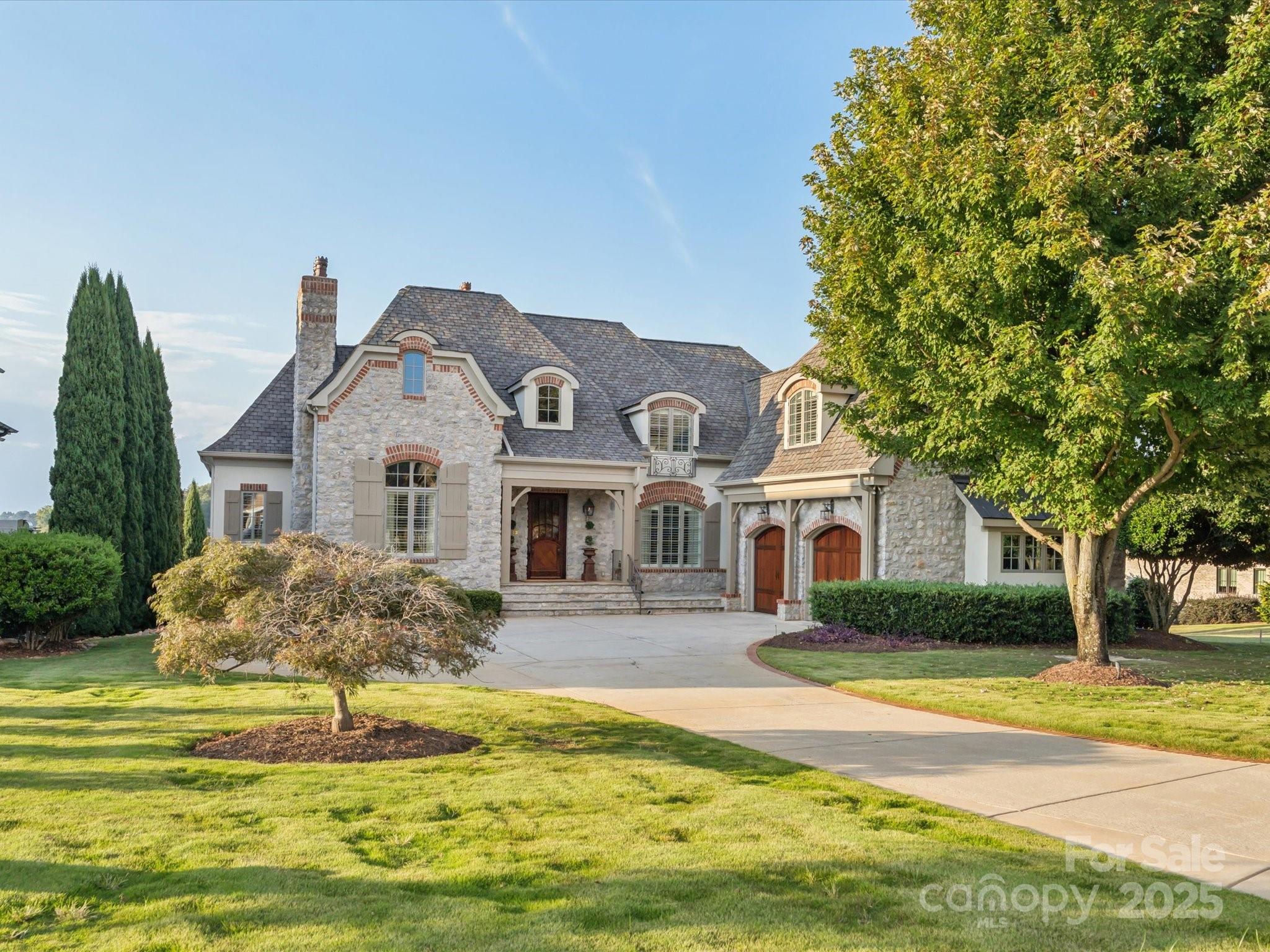 “A picture is worth a thousand words” is an understatement for this phenomenal French Country premier home located in the gated Joslin Pointe community!  From the beautiful curb appeal to the amazing views of Lake Wylie, there is not a detail that has been compromised in this place.  The main floor primary bedroom suite features gracious space and views, luxurious bathroom with tile shower, freestanding soaking tub, and dual vanities, as well as an expansive primary closet with packing island and washer/dryer.  The gourmet kitchen features a 60” Wolf dual fuel range with double griddle, microwave drawer, Bosch dishwasher, built-in Sub Zero appliances including refrigerator, ice maker, two freezer drawers, and wine chiller.  The island, dining area, and brand new custom automated shades will be great assets as you entertain your guests.  The dining room is perfect for sharing both formal meals or everyday dinners around the table.  Cozy up by the two-story stone fireplace with gas logs in the family room that opens to the kitchen and provides a doorway to the covered veranda.  The living room, with the second gas fireplace on the main level, is ideal for privacy, if needed – and could easily serve as a home office. The gorgeous spiraling staircase in the foyer and a second staircase off the kitchen lead to a second floor that features an apartment suite with bedroom, private bath, and kitchen-ready space with built-in refrigerator/freezer drawers. Two additional bedrooms and bathrooms, as well as a sitting area and flex room complete the upper level.  You will love the possibilities this space provides, including the storage.  Don’t forget to check out the water views! As if this was not enough, you will be enthralled with the finished basement area that boasts a second kitchen, incredible entertainment space with pool table, family room with stone fireplace and gas logs, dining area, movie theater with stadium seating and enhanced lighting system, bedroom, full bath, and wine storage room.  In addition, there is a second washer/dryer on the lower level.   Outdoor living and socializing will take on new meaning with the covered verandas on the main level and lower level that provide an incredible space for you and your guests to relax and enjoy the lavish life of lakefront living.  Relax on your private beach and enjoy the incredible sunsets across the lake. Looking for a place for your boat?  This one has the perfect spot with a private dock and boat lift!  Come see all this enchanting home offers and picture yourself as the next residents of 527 Joslin Pointe Lane.