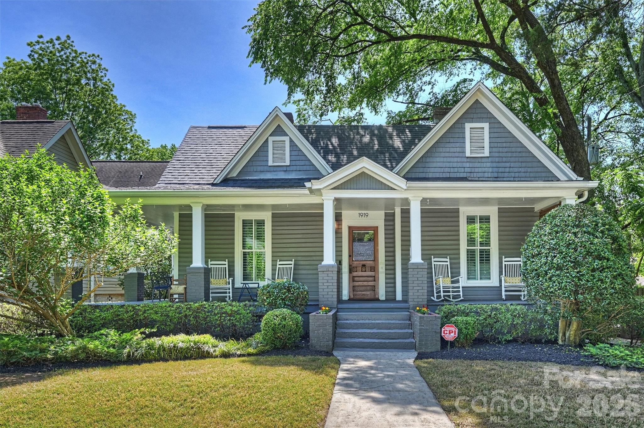 1919 Springdale is a charming Dilworth bungalow that blends classic character with exceptional space and flexibility. The home was thoughtfully expanded with a significant addition completed in 2018.  With 6 bedrooms—including two primary suites—this home offers a rare opportunity to accommodate a variety of living needs, from multigenerational living to guest space or work-from-home setups. Inside, warm and inviting living areas are seamlessly connected, creating an easy, modern flow. The centrally located kitchen opens to both dining and living spaces, making it ideal for everyday living and entertaining alike.  Both primary bedrooms provide comfort and privacy, each featuring ample space, large closets, and well-appointed bathrooms. Additional bedrooms are generously sized and versatile—ideal for guest rooms, offices, or fitness space. Upstairs includes two bedrooms, a spacious bathroom, loft area, and an oversized walk-in storage room.  Outdoor living is just as inviting, starting with the classic wrap-around front porch that immediately welcomes you home. The backyard features a stone paver patio, dedicated grilling, lounge area, and green space for relaxing or entertaining. A detached two-car garage adds convenience and valuable storage—an uncommon feature in Dilworth.  Located just minutes from South End, Uptown, parks, and local dining, this home offers the charm of a historic neighborhood with the space and functionality today’s buyers are looking for.