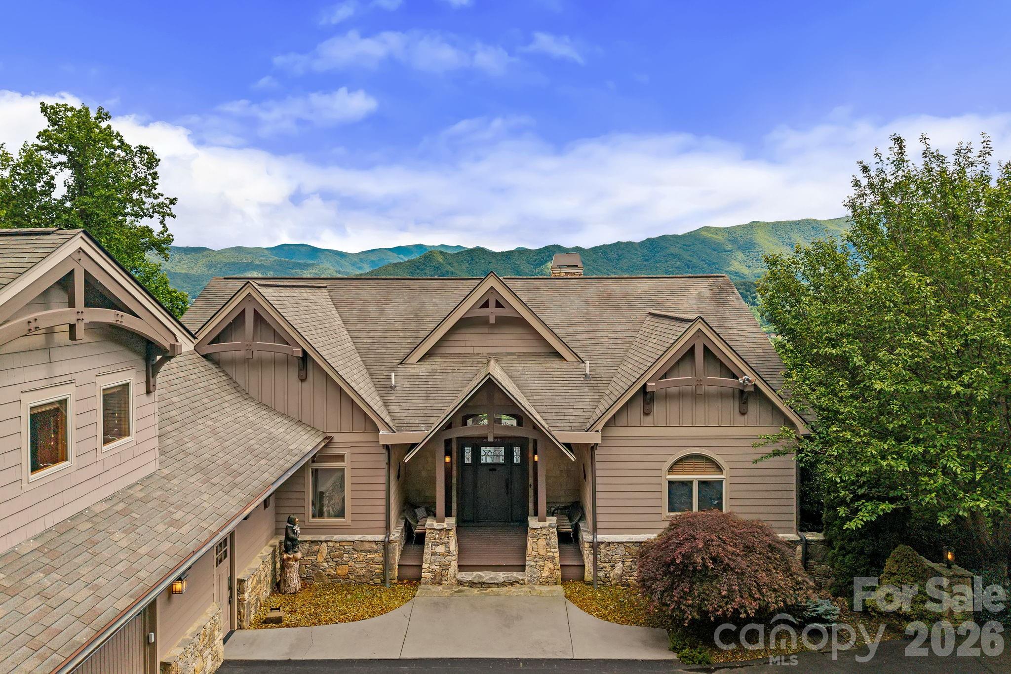 Commanding breathtaking long-range mountain views, this exceptional custom-built timber-frame home is a masterful expression of mountain luxury, exceptional craftsmanship, and architectural design in the prestigious Laurel Ridge Country Club community. 

Designed to embrace its spectacular setting, soaring cathedral ceilings, dramatic arched timber frame trusses, and a floor-to-ceiling stone fireplace set the tone throughout the home, while expansive windows frame breathtaking Blue Ridge Mountain views and fill the interior with natural light. Rich hardwood floors, custom millwork, and thoughtfully curated finishes create a warm, inviting atmosphere that perfectly balances grandeur with comfort.

Spanning more than 4900 square feet, the beautifully conceived floor plan flows effortlessly from the chef's kitchen to the grand living and dining spaces before extending to expansive covered decks overlooking the Mountains. The main-level primary suite offers a luxurious escape with panoramic views and a spa-inspired bath featuring handcrafted river rock walls, a soaking tub, oversized walk-in shower, and dual vanities. A finished 679-square-foot suite above the garage with a full bath provides exceptional flexibility, while the walkout lower level impresses with a showstopping custom bar, recreation room, second stone fireplace, guest accommodations, and deck access.

Just moments from the Laurel Ridge Country Club clubhouse and championship Bob Cupp-designed golf course, this extraordinary residence presents a rare opportunity to enjoy one of Waynesville's premier mountain lifestyles. Optional club memberships provide access to the impressive 19,000-square-foot Grand Lodge clubhouse, exceptional dining, championship golf, tennis, pickleball, a heated saltwater pool, fitness center, and an active social calendar. Club membership is available separately and is not included with the purchase of the property.