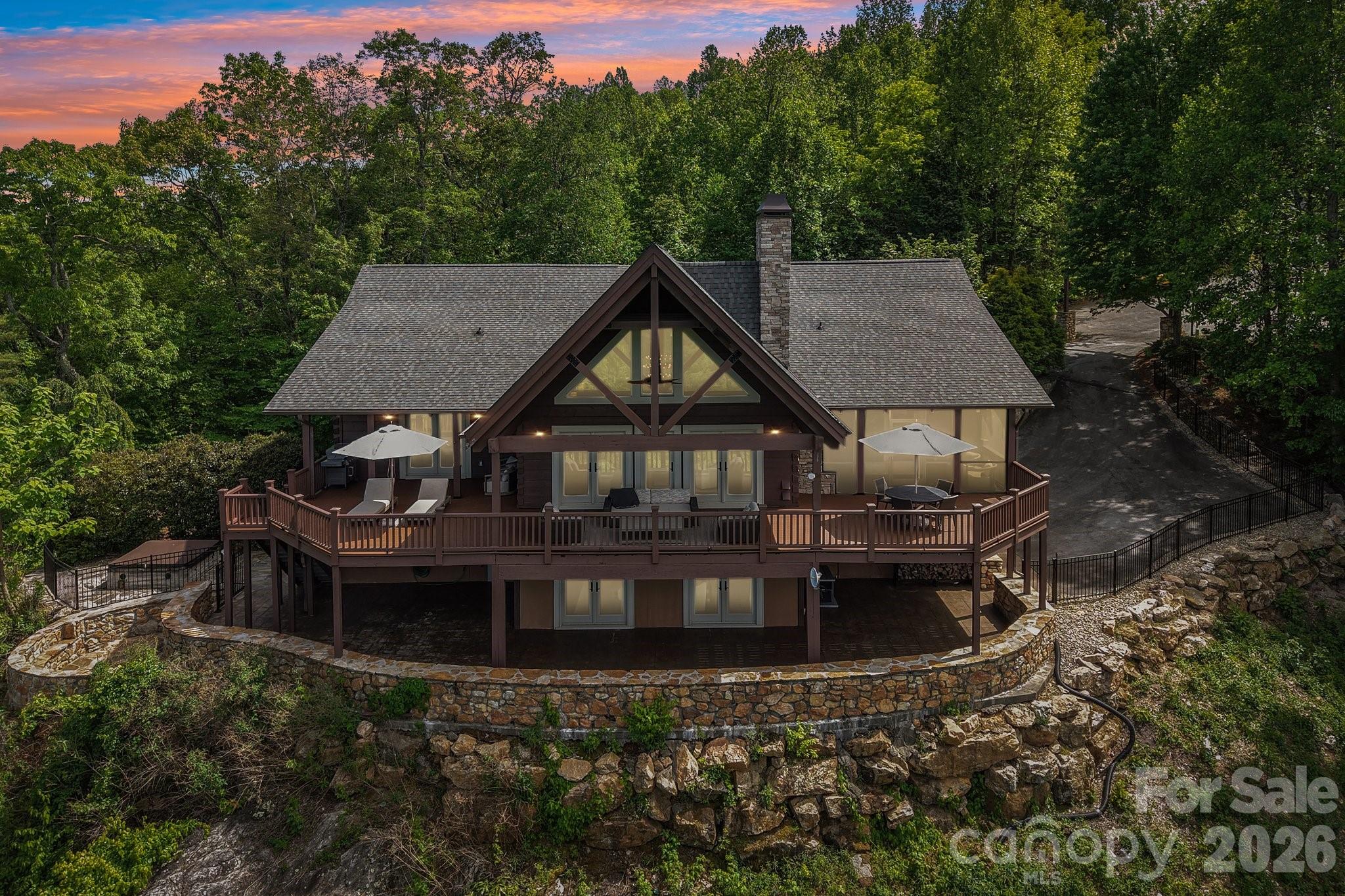 Amazing elevated mountain living with breathtaking year-round panoramic views! Imagine starting each morning with coffee on the deck as the sun rises over the mountains. Nestled on a private 2.77-acre cul-de-sac lot, this stunning home blends rustic luxury with contemporary design in a truly unforgettable setting.

Designed with post-and-beam architecture, the home features vaulted ceilings, an open floor plan, and spectacular views from nearly every room. The gourmet kitchen is a chef’s dream, complete with a Sub-Zero refrigerator, commercial-grade stove, and Brazilian wood countertops. In the great room, a magnificent stone fireplace frames the incredible long-range views of the Blue Ridge Mountains.

The loft provides the perfect office or reading retreat. Upstairs, the primary suite offers extraordinary mountain vistas, a spa-inspired bath, and a private screened porch with its own fireplace—ideal for peaceful evenings year-round.

The lower level was thoughtfully designed for entertaining, featuring an expansive family room, wet bar, full-size refrigerator, and covered private porch. In addition to the large family room downstairs, the home also features a second primary suite.  All bathrooms have been beautifully remodeled to complement the home’s refined contemporary style.

Outside, enjoy professionally landscaped grounds with a sunken fire pit and stone seating area, creating a perfect place to gather under the stars.

Located in Mountain Vista, a beautiful gated community known for its welcoming neighbors, this home offers both privacy and convenience—just 5 minutes to charming downtown Saluda and only a short drive to Hendersonville, Asheville, and Greenville. Best of all, access is easy with paved roads all the way to the property.