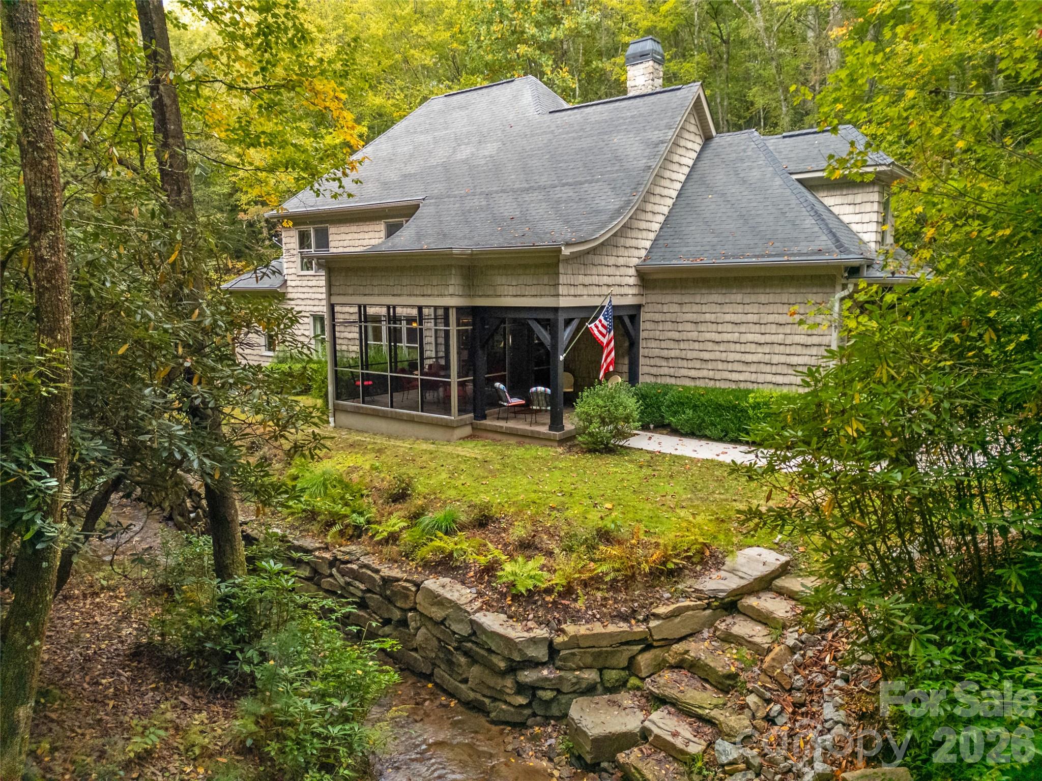 Truly One-of-a-Kind – Over an Acre with your very own Private Waterfall and Stream

This rare property offers the perfect balance of natural beauty and modern comfort. Set on more than an acre, it features its own bold stream and cascading waterfall, creating a private retreat right outside your door. The upgraded screened patio provides the ideal spot to enjoy your morning coffee or unwind with evening cocktails as you listen to the water.

Inside, the home is warm and inviting with wood floors throughout, elegant high ceilings, and surround sound in every room, thoughtful details at every turn. The living room area is centered around a stunning stacked stone fireplace, creating a warm and inviting gathering space. The open-concept kitchen with granite countertops flows easily into the main living areas, while music plays throughout in the surround sound speakers.

The primary suite on the main level is designed for comfort, with two walk-in closets and a spa-inspired bath complete with jetted tub, walk-in shower, dual vanities, and heated tile floors.

Upstairs, the home offers flexibility for both work and guests. One wing includes a custom built-in office and bonus room, while the opposite side has two guest bedrooms and a full bath.

Practical upgrades include a tankless water heater, and select areas wired for a portable generator.

This is more than just a home—it’s a retreat where nature and modern living come together. Properties like this, with a private waterfall and stream, are rarely available. Don’t miss your chance to own this extraordinary piece of the mountains.
First time homebuyer to CF pay a one time user  amenity fee in the amount $14,000.00 at closing.