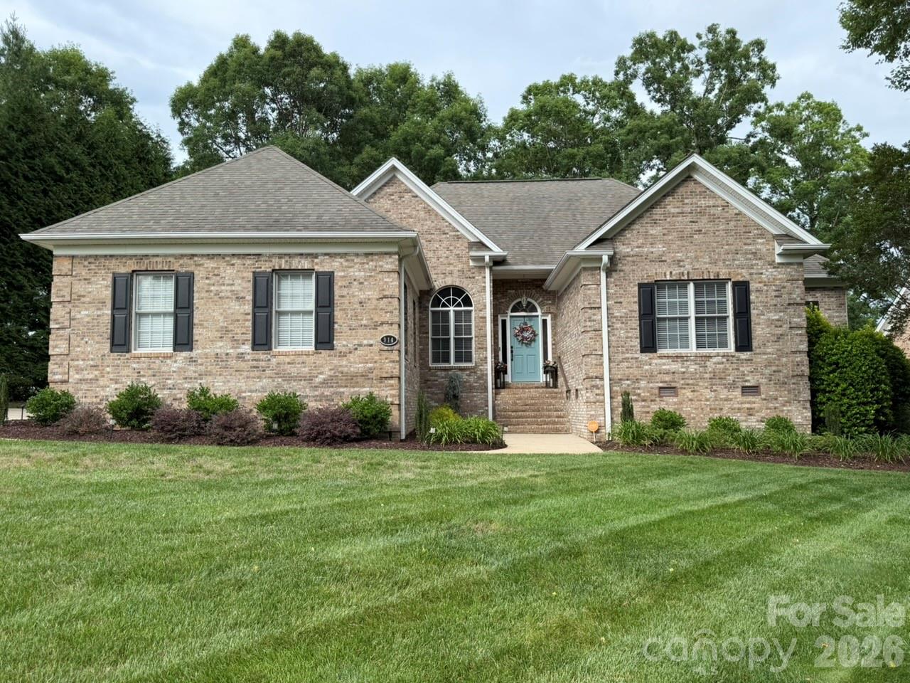 Stunning brick one level home in the 55+ community of The Woodlands located on the Oliver’s Landing golf course. This meticulously maintained 3 bedroom 2 ½ bathroom home features beautiful landscaping and attention to detail throughout. Buyers will love the open floorplan, high ceilings, arched doorways, abundance of natural light and beautiful details that greet them upon entering this amazing home. The foyer area opens directly into a bright dining room, and spacious great room offering a fireplace with gas logs. The well-appointed kitchen offers generous, new quartz counters with plenty of prep space, stainless steel appliances, pantry, a bar with seating and an eat-in area perfect for hosting a gathering. Exit the kitchen through french doors that open onto the deck which oversees the lush landscaping. The spacious and bright sunroom has easy access from the great room. You will want to spend all your time in this inviting sunroom which provides access to the enormous screen porch with tall ceilings both overlooking the private fenced backyard oasis. The primary suite has a tray ceiling, lots of windows, and a beautifully updated primary bath with tile floors and walk-in shower, new quartz counters with double sinks and a jetted tub. There is also a walk-in closet. The second bedroom is spacious and offers a built-in dresser and plenty of closet space with an updated shared bath with the 3rd bedroom.
This home offers an abundance of windows which allows for beautiful views of the outdoors as well as generous natural light. The front and back yards also have a sprinkler system. There have been many updates throughout, including all new light fixtures, faucets, door hardware, paint and more. You will find that this home has it all, and you can even step out from the backyard onto the 9th green.